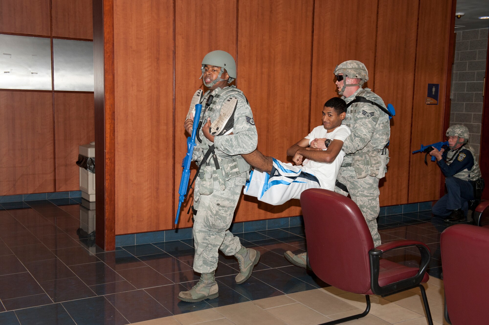 325th Security Forces Squadron Airmen carry a "victim" of an active shooter in the base fitness center as part of a base exercise. The exercise is designed to provide an opportunity to validate training effectiveness and make changes where needed with minimal risk to personnel and property. Tyndall generally executes up to four exercises per year and scenarios vary. (U.S. Air Force photo by Lisa Norman)