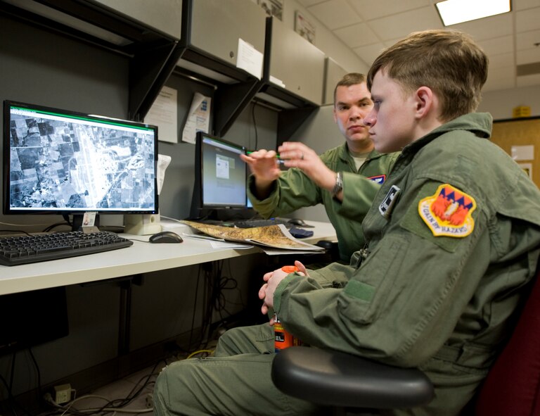 Capt. Phillip Newman, 317th Airlift Group, shows Keegan Vowell, 16-year-old Abilene resident, a map used before missions during a “Pilot for a Day” tour Jan. 14, 2013, at Dyess Air Force Base, Texas. Throughout the event, Keegan received his own flight suit, was demonstrated the capabilities of the 7th Security Forces K-9 Unit, toured the air traffic control tower, taxied a bomber, had his name put onto an aircraft, created his own Hollywood explosion with the 7th Civil Engineer Squadron Explosive Ordinance Disposal Unit and was presented a coin from the base commander. (U.S. Air Force photo by Airman 1st Class Jonathan Stefanko/ Released)