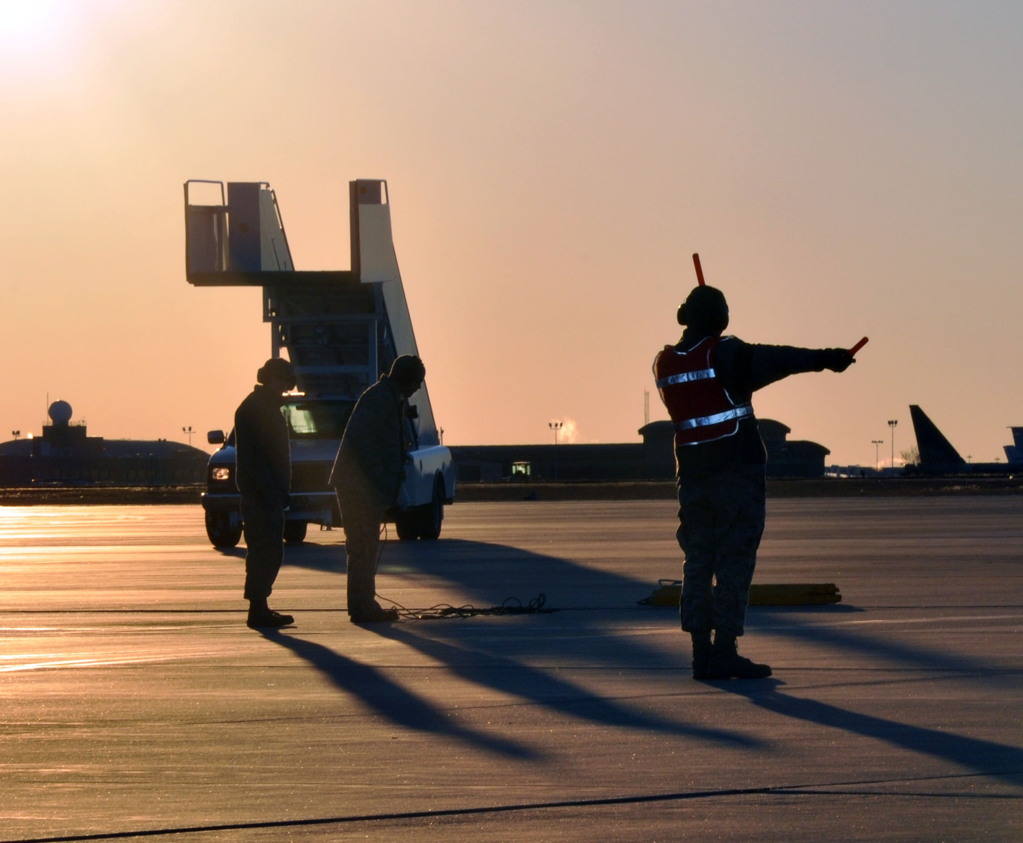 A member of the Air Force Reserve 931st Aircraft Maintenance Squadron directs a KC-135 Stratotanker to a parking place as the sun sets on the flightline at McConnell Air Force Base, Kan.  Aircraft maintainers are responsible for ensuring aircraft are ready for flight, as well as inspecting and maintaining planes when they return from a mission.  (U.S. Air Force photo by 1st Lt. Zach Anderson)