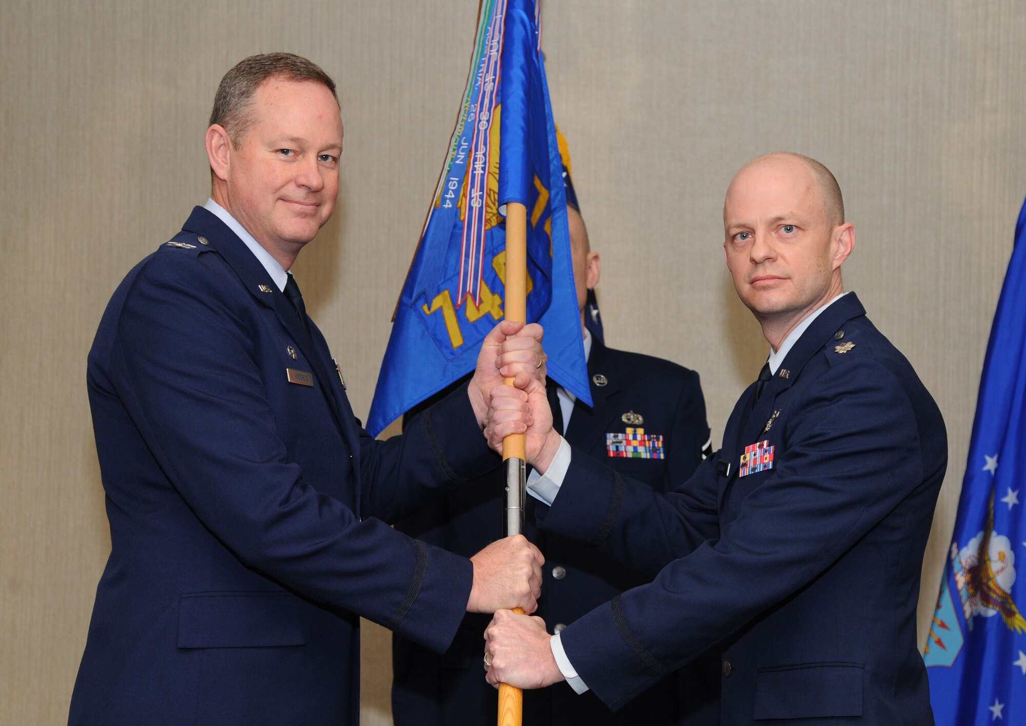 MINOT AIR FORCE BASE, N.D. --  Col. Bryan Haderlie, 91st Operations Group commander, hands off the 740th Missile Squadron guidon to Lt. Col. David Rickards, incoming 740th MS commander, during a Change of Command ceremony here, Jan. 17. The change of command also comes as part of a celebration signifying  50 years of the Missile Wing's mission of protecting and maintaining America’s missile assets. (U.S. Air Force photo/Airman 1st Class Andrew Crawford) 