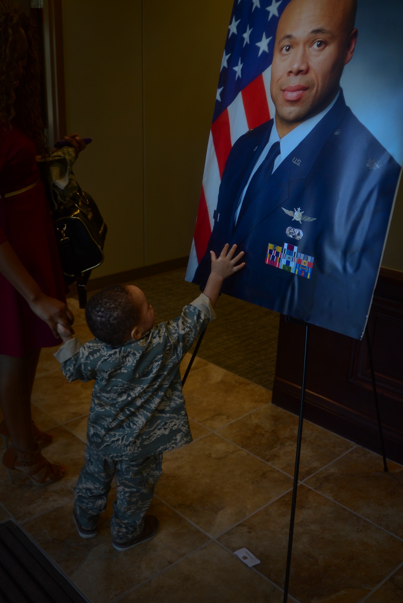 Raymond G. Estelle III, 22 months, touches a photo of his father, Maj. Raymond G. Estelle II, during a building dedication at MacDill Air Force Base Fla., Jan. 16, 2013. Estelle was one of nine people killed in action April 27, 2011 and served at MacDill AFB from 1999-2001. (U.S. Air Force photo by Senior Airman Melissa Paradise/Released)