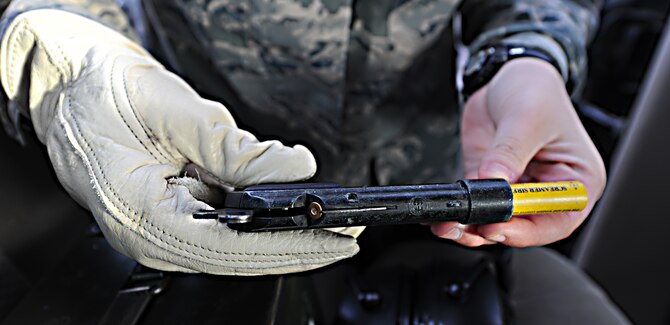 WHITEMAN AIR FORCE BASE, Mo. -- Airman 1st Class Heather Hall, 509th Operations Support Squadron airfield management coordinator, displays a delivery system for airfield pyrotechnics, Jan. 9. Airfield management coordinators utilize several types of pyrotechnics that aid in bird-threat dispersal. (U.S. Air Force photo/Staff Sgt. Nick Wilson) (Released)