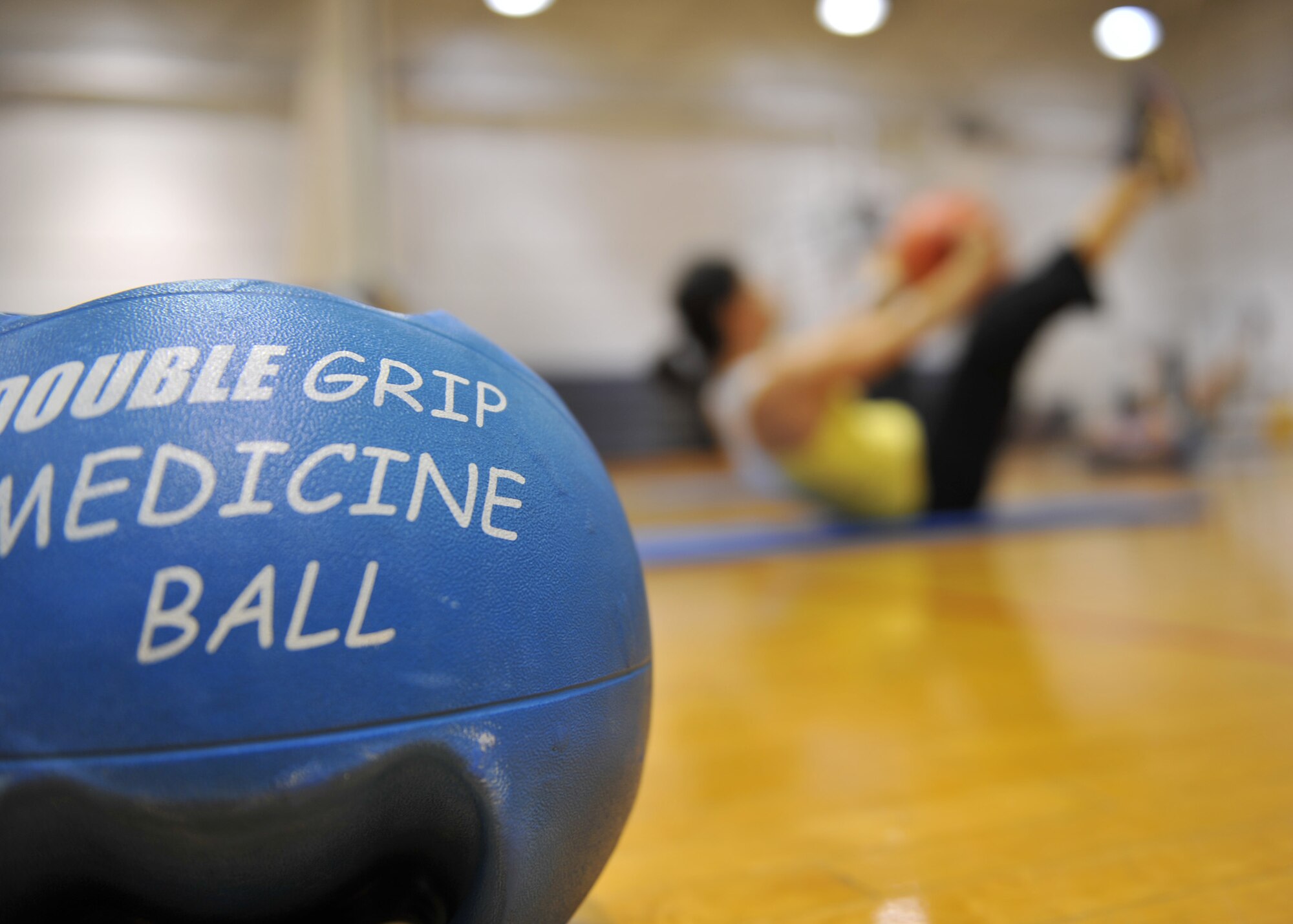 WHITEMAN AIR FORCE BASE, Mo. – Alicia-Ferris Dannenberg, Whiteman Fitness instructor, performs a sit-up with a medicine ball during a Guts & Glutes class at Whiteman Air Force Base’s Wing Fitness Day, Jan. 11. The event was used to introduce new instructors and their classes and educate Service members and their families on various fitness center activities. (U.S. Air Force photo/Heidi Hunt) (RELEASED)
