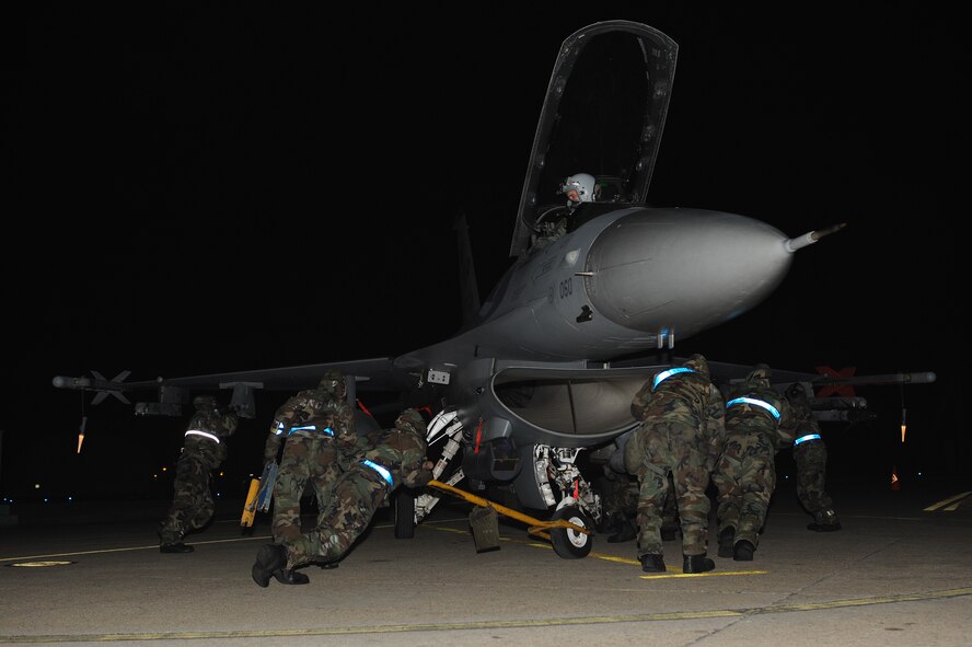 Members of the 35th Aircraft Maintenance Unit turn an F-16 Fighting Falcon that has been contaminated by a simulated chemical attack at Kunsan Air Base, Republic of Korea, Jan. 17, 2013. The contaminated aircraft needed to be cordoned off, and the pilot and plane decontaminated. (U.S. Air Force photo by Staff Sgt. Jonathan Fowler/Released)