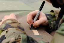 An Airman from the 8th Security Forces Squadron dates M-8 paper on his Humvee during Beverly Midnight 13-1 Kunsan Air Base, Republic of Korea, Jan. 17, 2013. The paper changes color when it comes in contact with liquid nerve, blister and chemical agents. (U.S. Air Force photo by Senior Airman Marcus Morris/released)