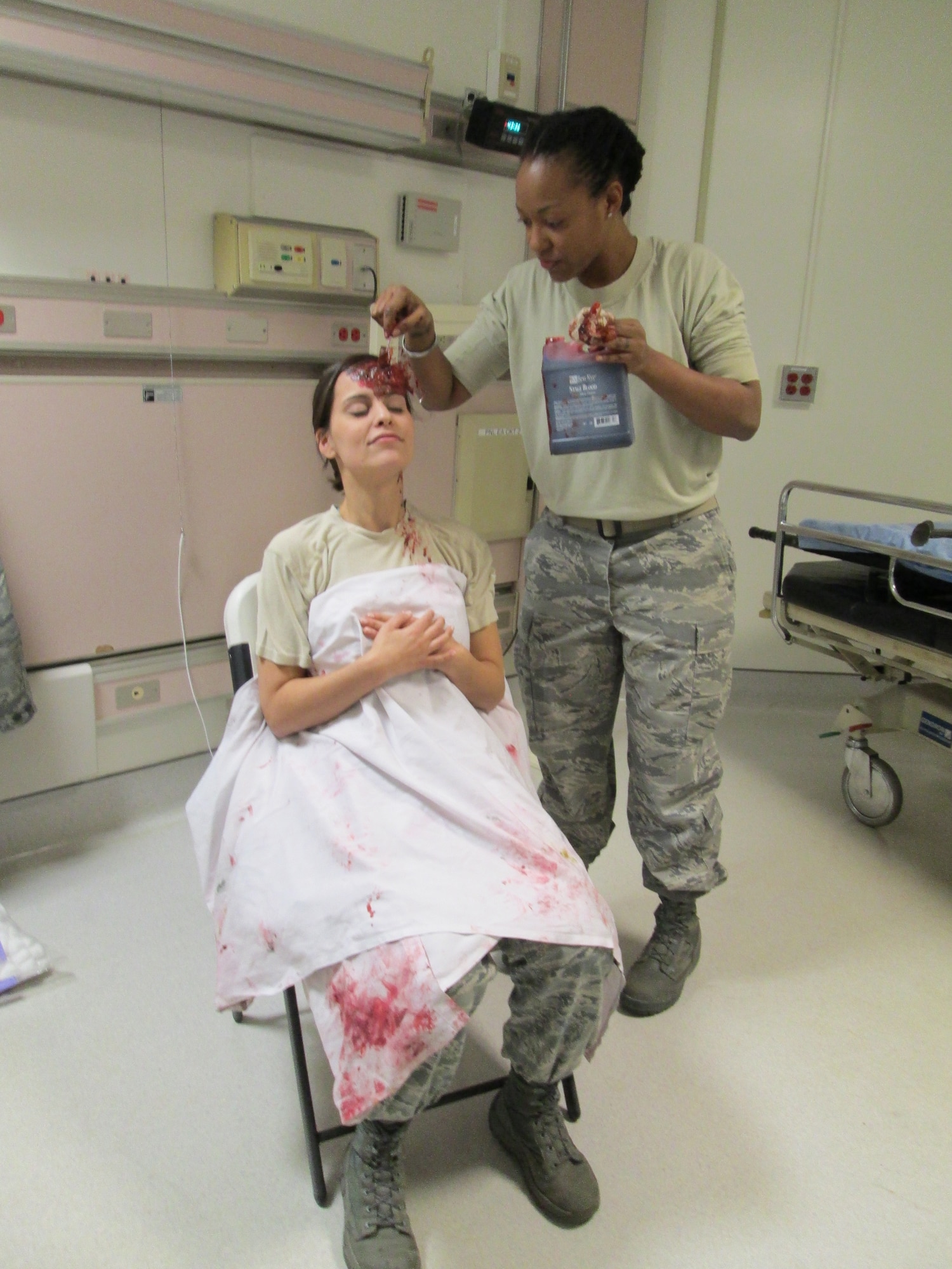 Tech Sgt. Erin Connolly (right) paints a moulage on Staff Sgt. Jennifer Cummings intended to simulated head trauma for a medical training held at Joint Base Andrews, January 10, 2013. The training is to prepare a medical team for their role in the 57th Presidential Inauguration as a medical response unit. Connolly is medical engineer and Cummings is a lab technician, both with the 79th Medical Wing. (U.S. Air Force Photo/Melanie Moore)