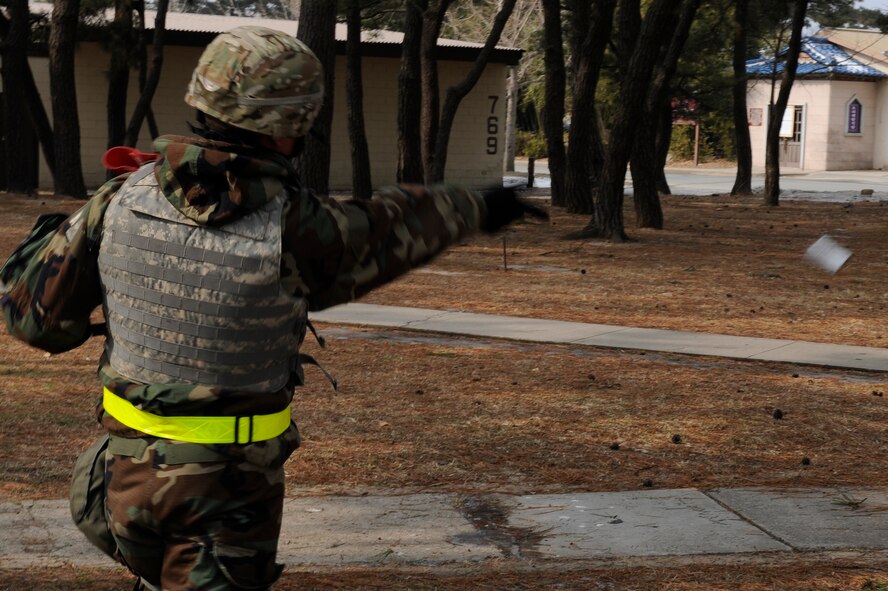 Tech. Sgt. Derek Keener, 8th Civil Engineer Squadron explosives ordnance disposal exercise evaluation team, throws a ground blast simulator (GBS) during exercise Beverly Midnight 13-1 at Kunsan Air Base, Republic of Korea, Jan. 17, 2013. The team used smoke machines and GBS to simulate a tactical ballistic missile attack on a compound. (U.S. Air Force photo by Senior Airman Marcus Morris/Released)