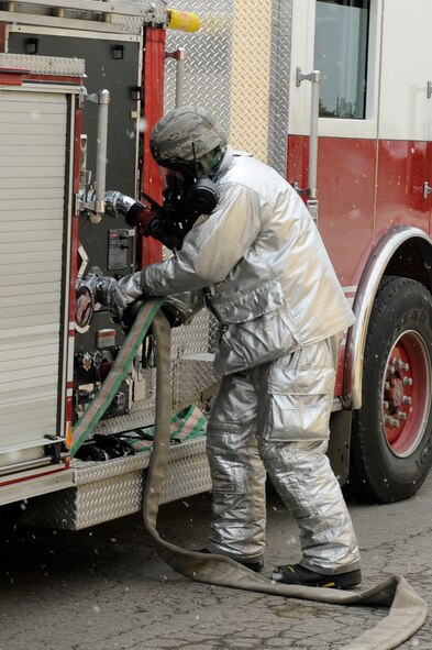 Staff Sgt. Timothy Vanden Haak, 8th Civil Engineer Squadron firefighter, connects hoses to the fire truck during exercise Beverly Midnight 13-1 at Kunsan Air Base, Republic of Korea, Jan. 17, 2013. The team quickly found the source of the smoke and extinguished the fire before more damage to the facility could be done. (U.S. Air Force photo by Senior Airman Marcus Morris/Released)