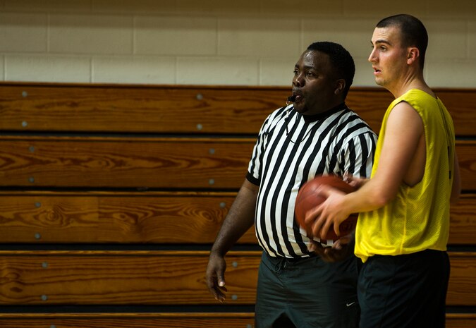 Referee Julius Murray hands the basketball to James Kirbie, 628th Logistics Readiness Squadron, before attempting an inbound pass Jan. 15, 2013, at Joint-Base Charleston, S.C.  628th LRS beat the 628th Security Forces Squadron by a score of 59 to 49 in the season opener of the 2013 intramural season. (U.S. Air Force photo/Staff Sgt. Rasheen Douglas)