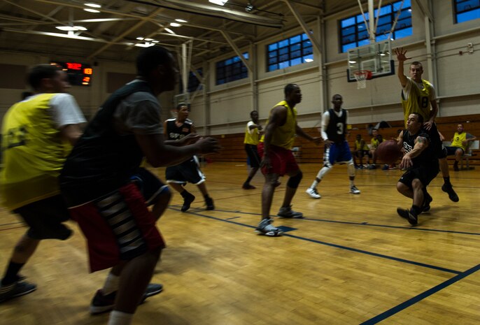 Eddie Sanchez, 628th Security Forces Squadron, attempts a pass to Keith Garrett, 628th SFS, underneath the basket during an intramural game Jan. 15, 2013, at Joint-Base Charleston, S.C.  The 628th SFS lost to the 628th Logistics Readiness Squadron by a score of 59 to 49 in the season opener of the 2013 intramural season. (U.S. Air Force photo/Staff Sgt. Rasheen Douglas)