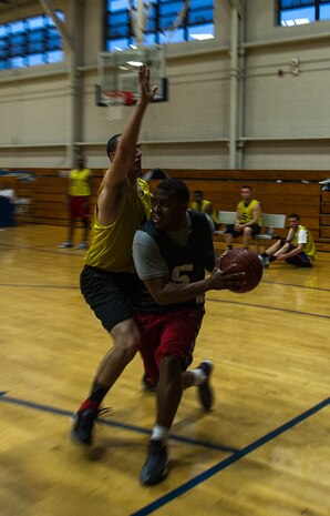Keith Garrett, 628th Security Forces Squadron, runs the baseline as James Kirbie, 628th Logistics Readiness Squadron, attempts to defend him from driving to the basket Jan. 15, 2013, at Joint-Base Charleston, S.C.  628th LRS beat the 628th Security Forces Squadron by a score of 59 to 49 in the season opener of the 2013 intramural season. (U.S. Air Force photo/Staff Sgt. Rasheen Douglas)