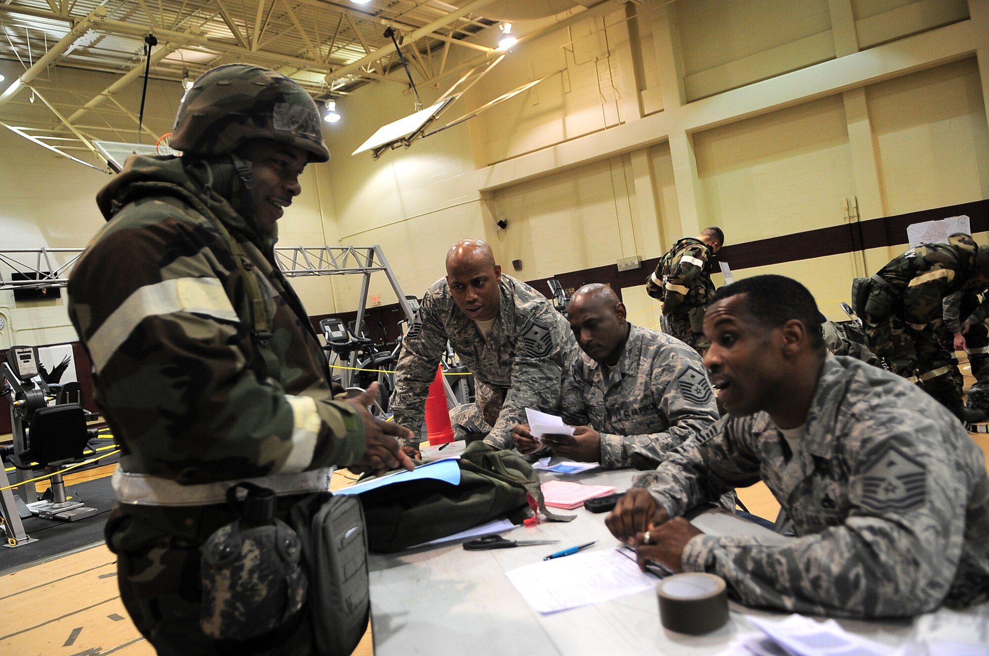 First sergeants assigned to the 4th Fighter Wing verify U.S. Air Force Master Sgt. Antonio Booker, 4th Equipment Maintenance Squadron aircraft ground equipment craftsman, is prepared to transition into the exercise play area on Seymour Johnson Air Force Base, N.C., Jan. 17, 2013. Several First sergeants worked at the transition area to ensure deploying Airmen maintained mission readiness. (U.S. Air Force photo/Airman 1st Class Aubrey White/Released)