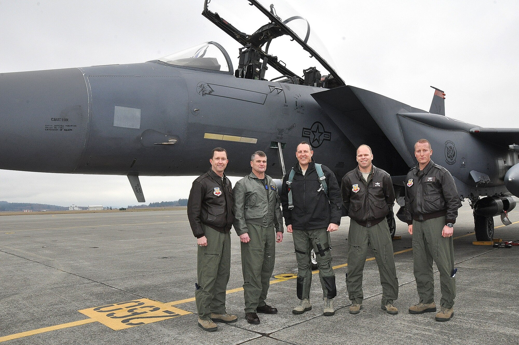 An F-15E “Strike Eagle” from Mountain Home Air Force Base, Idaho, arrives Jan. 14 to NAS Whidbey Island with U.S. Air Force Col. Christopher Short (center), Commander, 366th Fighter Wing, aboard to visit the 390th Electronic Combat Squadron. He is met by Col. Christopher Sage, 366th Operations Group Commander (far left); Capt. Jay Johnston, NAS Whidbey Island Commanding Officer; Lt. Col. Karl Fischbach, 390th ECS Commander; Lt. Col.  Don Keen, 390th ECS Operations Officer.  With 16 U.S. Air Force fliers assigned to NAS Whidbey Island under the Electronic Attack Wing, U.S. Pacific Fleet umbrella, Short came for an annual squadron status visit and get a “Growler ride” in a simulator. (Tony Popp photo)