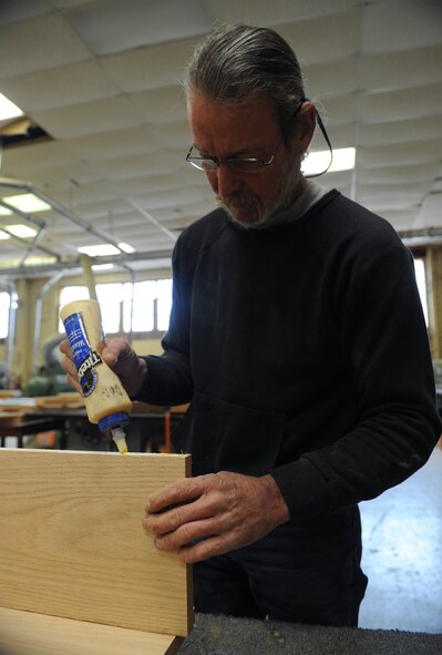 Mike Jarrett, 2nd Force Support Squadron wood craft shop, puts wood glue on a piece of lumber on Barksdale Air Force Base, La., Jan. 16. The wood craft shop receives requests ranging from shadow boxes to trophy shelves. Certified individuals can use the facility and rent tools for their own wood shop projects. (U.S. Air Force photo/Airman 1st Class Benjamin Gonsier)