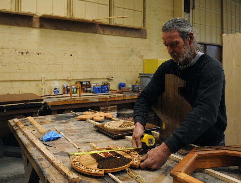 Mike Jarrett, 2nd Force Support Squadron wood craft shop, measures one of his wood designs on Barksdale Air Force Base, La., Jan. 16. The wood craft shop makes shadow boxes, podiums, trophy cases and coin racks. Every month, the wood craft shop offers a four-day woodworking class where beginners can be certified to use woodworking equipment. (U.S. Air Force photo/Airman 1st Class Benjamin Gonsier)