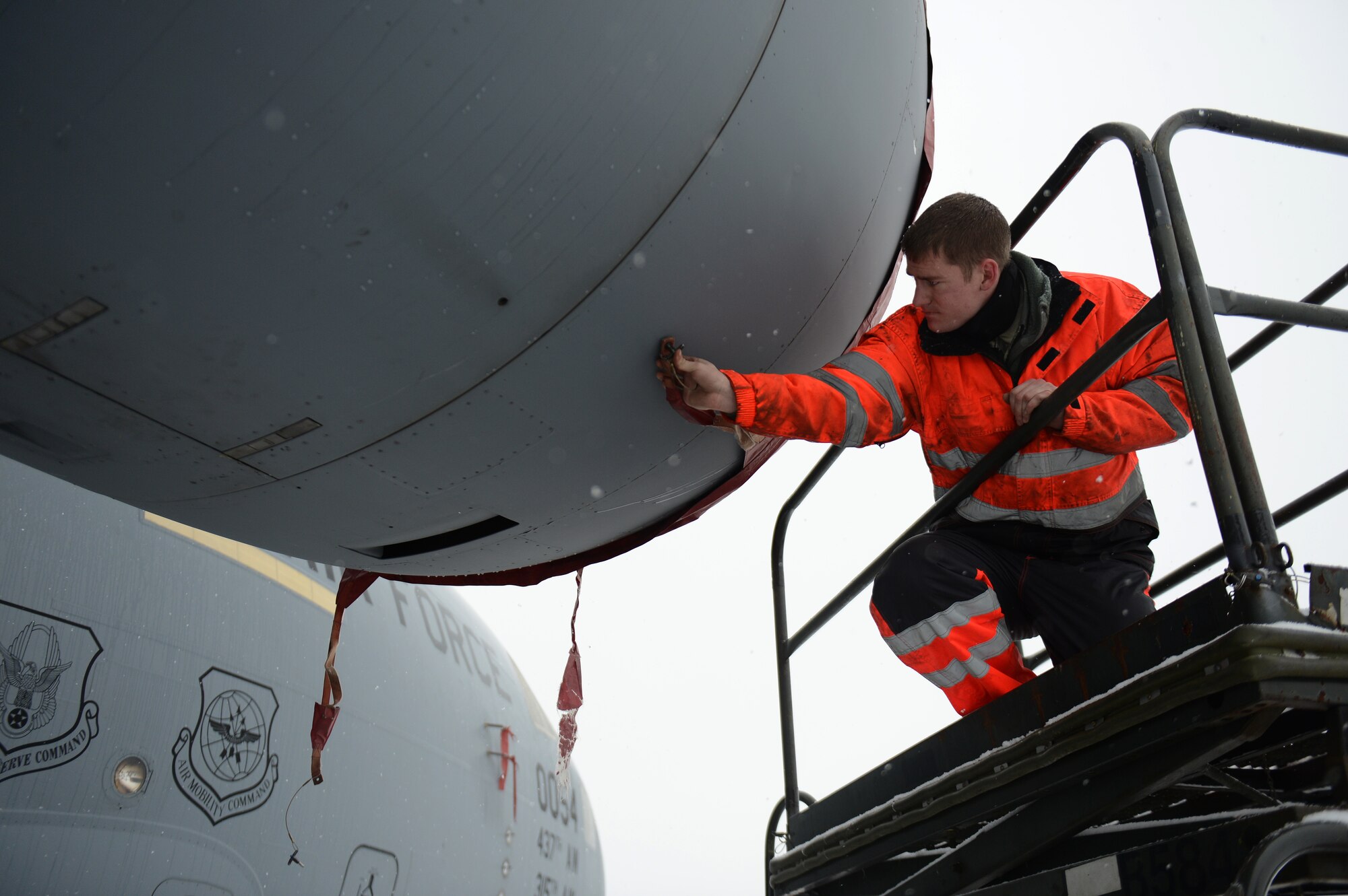 SPANGDAHLEM AIR BASE, Germany – U.S. Air Force Senior Airman Daryl Treadwell, 726th Air Mobility Squadron integrated flight control systems technician from Austin, Texas, applies an engine cover to a C-17 Globemaster III cargo aircraft Jan. 15, 2013.  The four engines are covered to prevent snow from accumulating in the engine inlets. (U.S. Air Force photo by Airman 1st Class Gustavo Castillo/Released)
