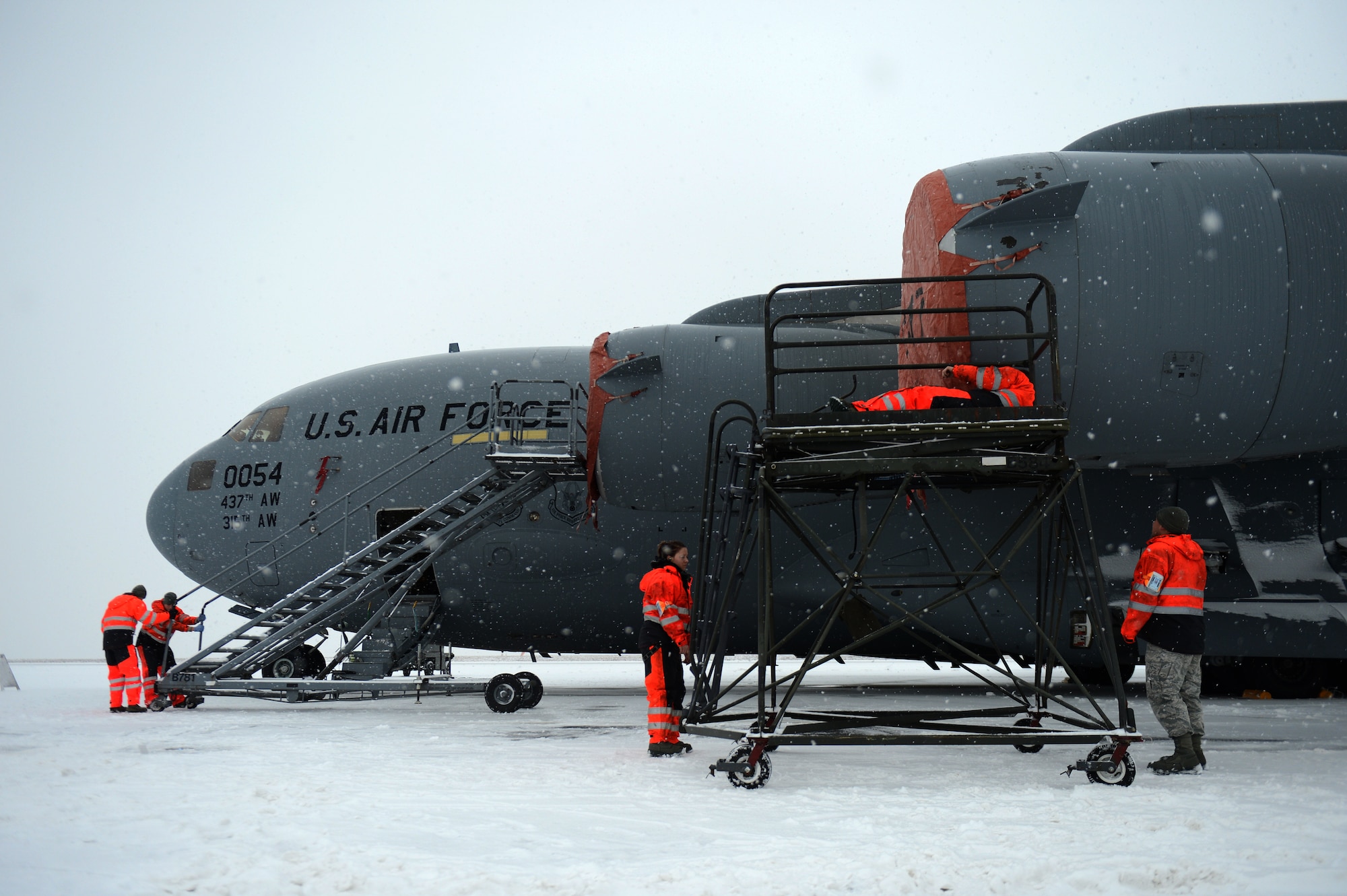 SPANGDAHLEM AIR BASE, Germany – Airmen from the 726th Air Mobility Squadron secure engine covers on a C-17 Globemaster III cargo aircraft Jan. 15, 2013. The covers are secured by six pins and then tightened to reduce the effects of extreme weather conditions on an engine at rest. (U.S. Air Force photo by Airman 1st Class Gustavo Castillo/Released)