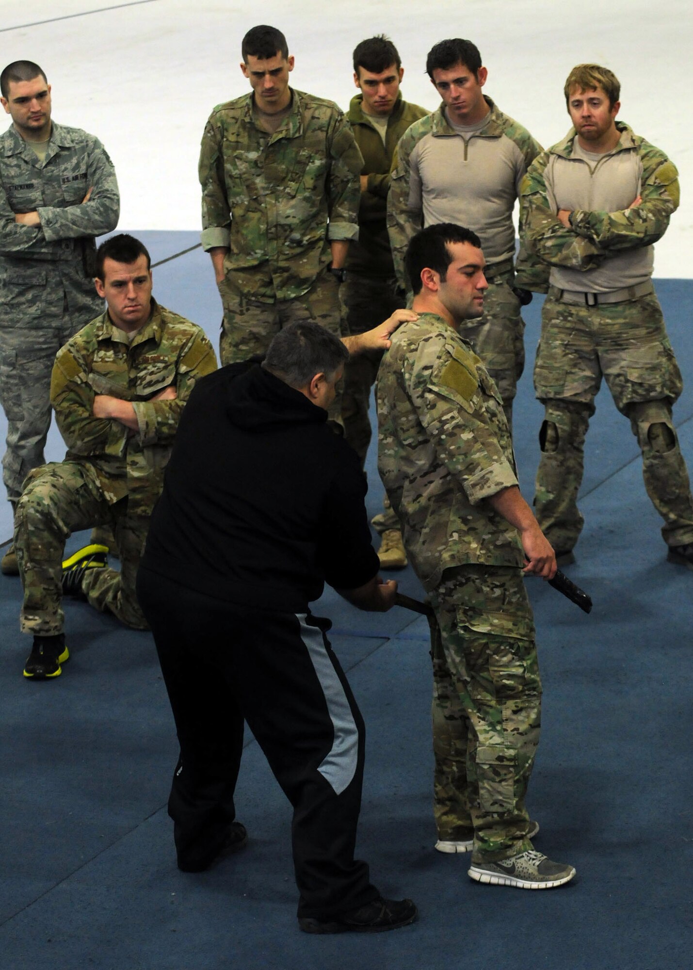 A combatives instructor demonstrates a knife technique on an Airman from the 321st Special Tactics Squadron Jan. 11, 2013, in building 539 at RAF Mildenhall, England. The Airmen receive training regularly to keep their skills up-to-date. (U.S. Air Force photo by Airman 1st Class Kelsey Waters/Released)