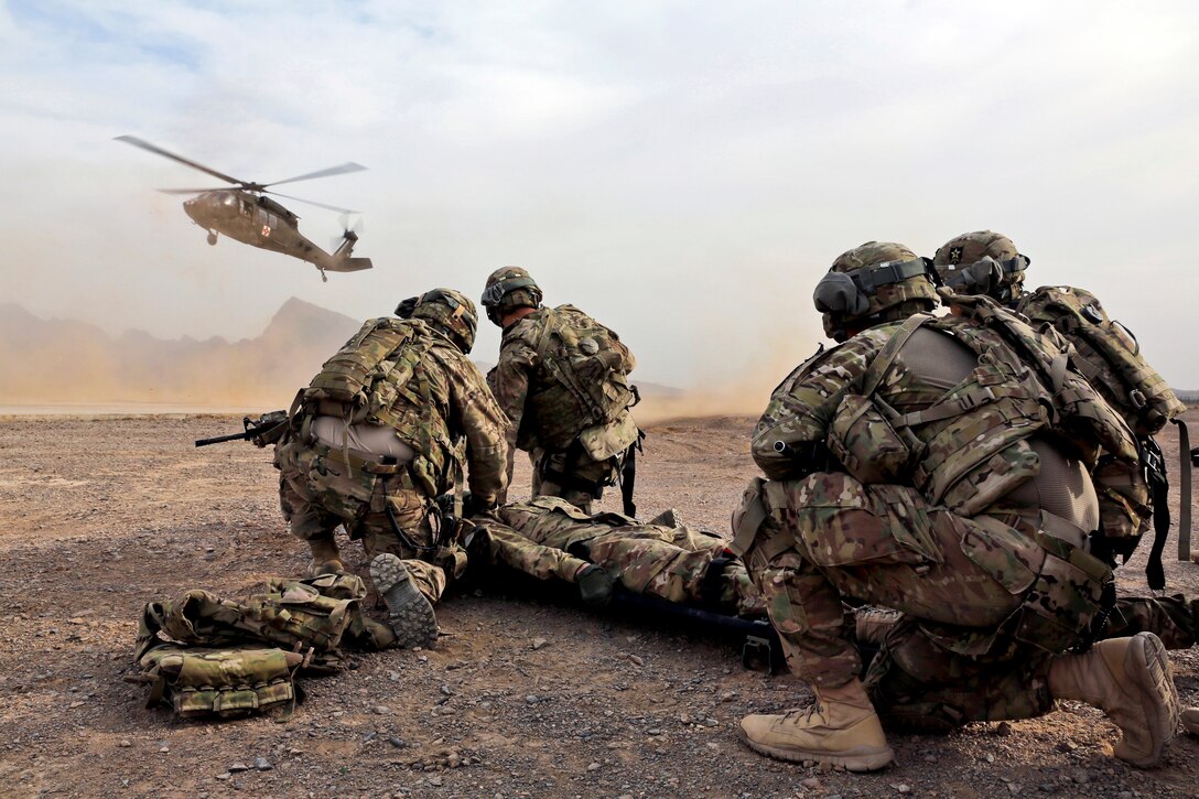 U.S. troops wait for a UH-60 Black Hawk medevac helicopter to land before moving a simulated casualty during medical evacuation training on Forward Operating Base Farah, Afghanistan, Jan. 9, 2013. The troops are assigned to Provincial Reconstruction Team Farah.