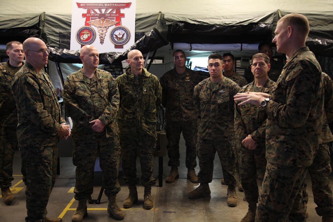 Cmdr. Joe T. Patterson, right, explains how 3rd Medical Battalion is aiding III Marine Expeditionary Force with its mission to, from left, Rear Adm. Michael H. Anderson, Rear Adm. Charles Harr, and Navy Capt. John P. LaBanc Jan. 15 at Camp Foster. The battalion designed III MEF’s first medical pre-deployment training facility, according to Lt. Eva Reed, the officer-in-charge of the 3rd Medical Battalion simulated trauma and advanced training center. Patterson is the commanding officer of the battalion, which is part of Combat Logistics Regiment 35, 3rd Marine Logistics Group, III Marine Expeditionary Force. Anderson is the Medical Officer of the Marine Corps, Harr is the deputy Medical Officer of the Marine Corps, and LaBanc is the III MEF surgeon. (U.S. Marine Corps photo by Lance Cpl. Alyssa N. Hoffacker)


