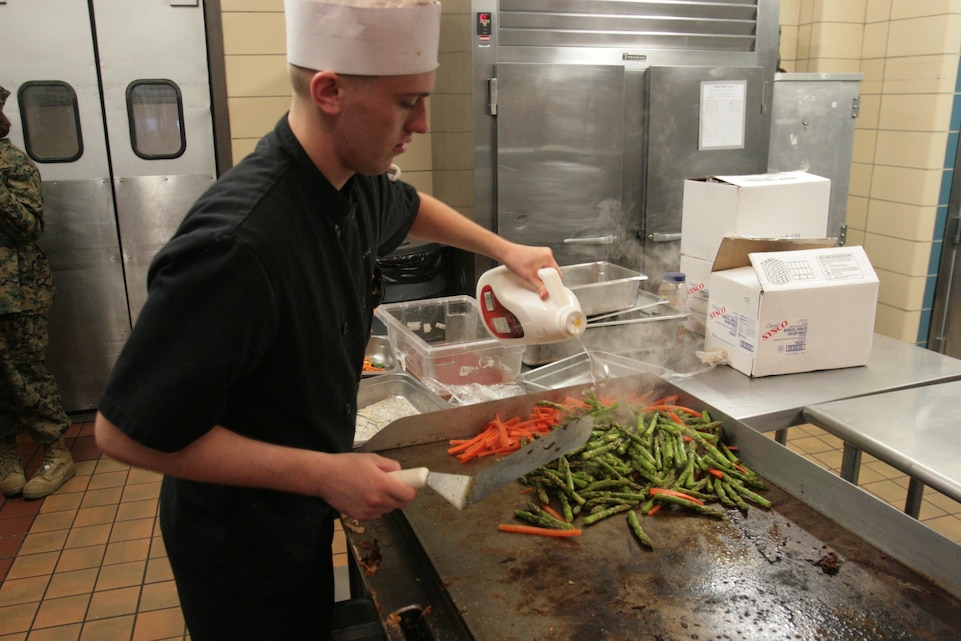 Lance Cpl. Zachery Schram, a food service specialist with Marine Wing Support Squadron 271, pours oil as he sautés carrots and asparagus during the Chef of the Quarter competition at the Cherry Point mess hall Jan. 10. Schram won the competition with a meal of stuffed chicken breast, potatoes au gratin and a frozen berry and fruit coulis. “I just wanted to make something that I could be proud of,” Schram said. “I wanted to make something that would remind me of home.”