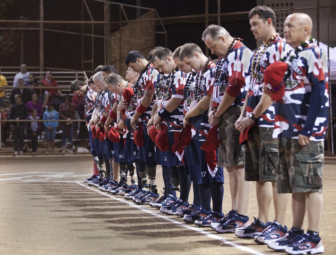 WAIPAHU - Wounded Warrior Amputee Softball Team members render respect during the opening ceremonies before a softball game against the Honolulu Veterans Affairs team at the Central Oahu Softball Complex, Jan. 9. The team, comprised of 14 active duty and retired Marines and soldiers, play despite amputations they sustained while supporting combat operations in Afghanistan and Iraq. They bombarded their opponents, Honolulu Veterans Affairs, with line drives and home runs to finish on top, 20-8. (official U.S. Marine Corps photo by Lance Cpl. Nathan Knapke)
