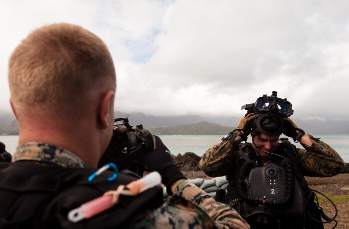 MARINE CORPS BASE HAWAII - Lance Cpls. Cody Wurdelman and Andrew Maltz, natives of Chicago and Pearl River, Calif., and reconnaissance men with Bravo Company, 3rd Reconnaissance Battalion, don their full face masks before entering the water for a dive training evolution at the 4th Force Reconnaissance Company compound on Marine Corps Base Hawaii, Jan. 9. The training was part of Exercise Sandfisher 2013, which was held on Marine Corps Base Hawaii from Jan. 7 to 18 to strengthen all participants’ tactics in amphibious procedures and combat diving. (Official U.S. Marine Corps photo by Cpl. James A. Sauter)