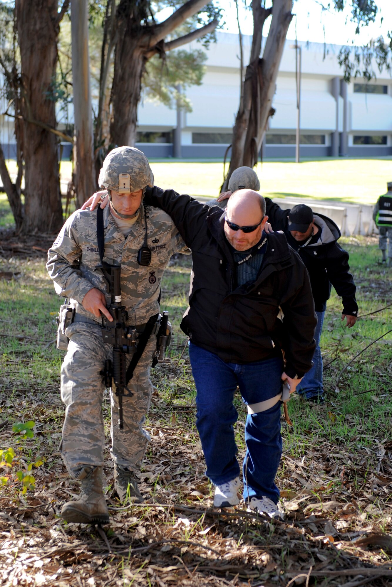 VANDENBERG AIR FORCE BASE, Calif. -- A 30th Security Forces Squadron member helps an 'injured' role player move to a holding area during an active shooter scenario outside a facility here, Thursday, Jan. 18, 2013. The exercise was Team V's final emergency management scenario to sharpen their crisis response skills before the installation's upcoming Unit Compliance Inspection. (U.S. Air Force photo/Staff Sgt. Levi Riendeau)
