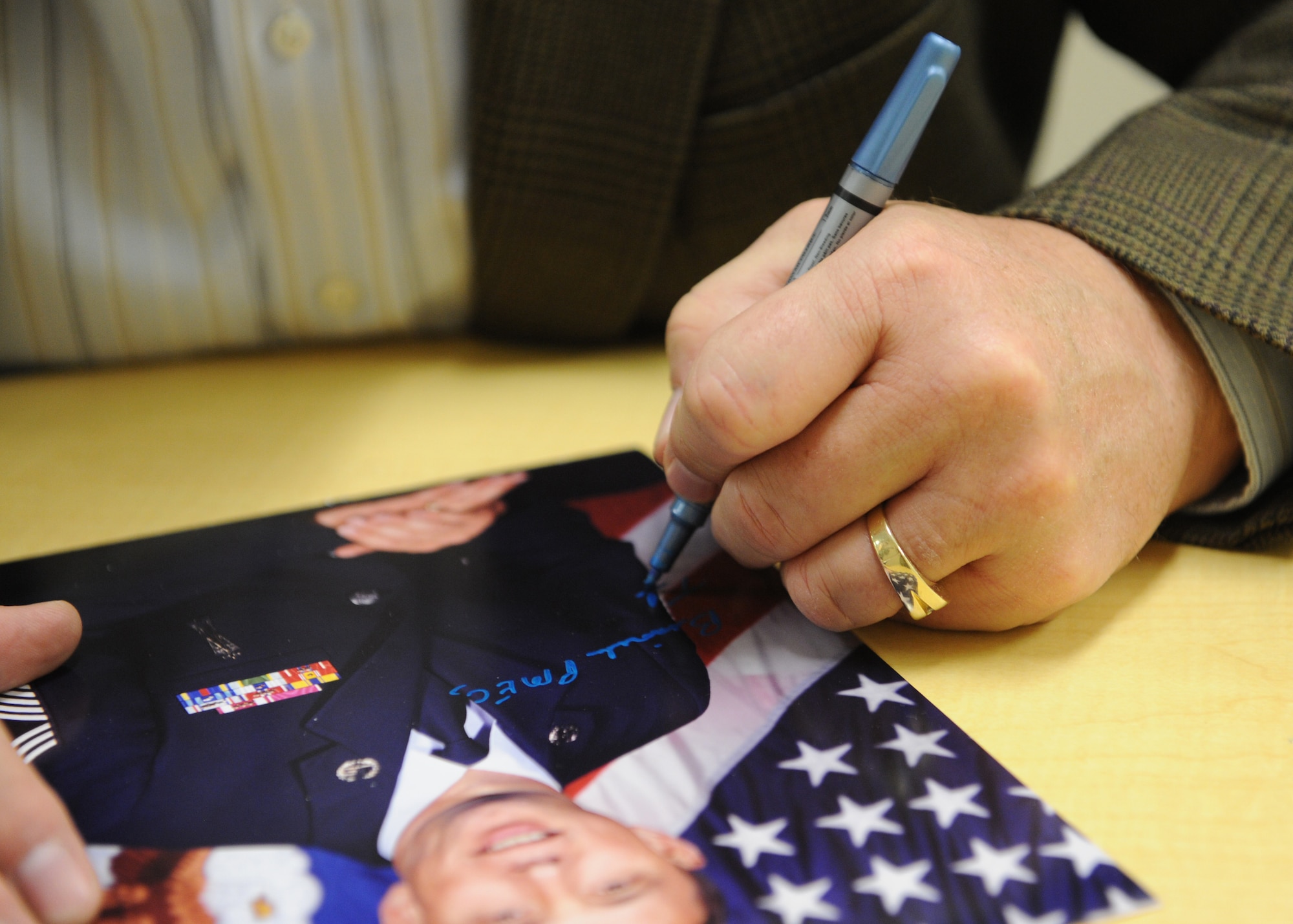 Retired Chief Master Sgt. of the Air Force Frederick J. Finch autographs his official portrait that hangs in the hallway of the Binnicker Professional Military Education Center during his visit, at Joint Base Pearl Harbor-Hickam, Hawaii, Jan. 18, 2013. Finch is the thirteenth chief master sergeant of the Air Force. (U.S. Air Force photo/Tech. Sgt. Jerome S. Tayborn)
