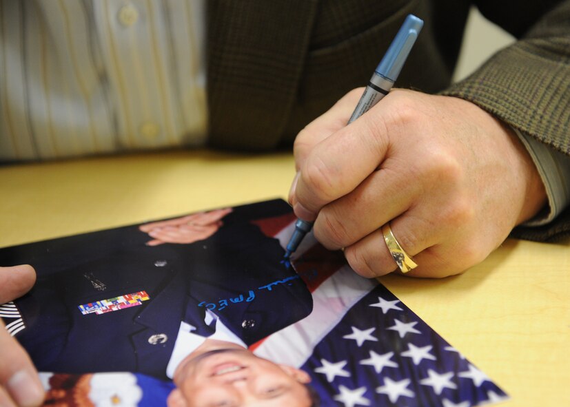 Retired Chief Master Sgt. of the Air Force Frederick J. Finch autographs his official portrait that hangs in the hallway of the Binnicker Professional Military Education Center during his visit, at Joint Base Pearl Harbor-Hickam, Hawaii, Jan. 18, 2013. Finch is the thirteenth chief master sergeant of the Air Force. (U.S. Air Force photo/Tech. Sgt. Jerome S. Tayborn)