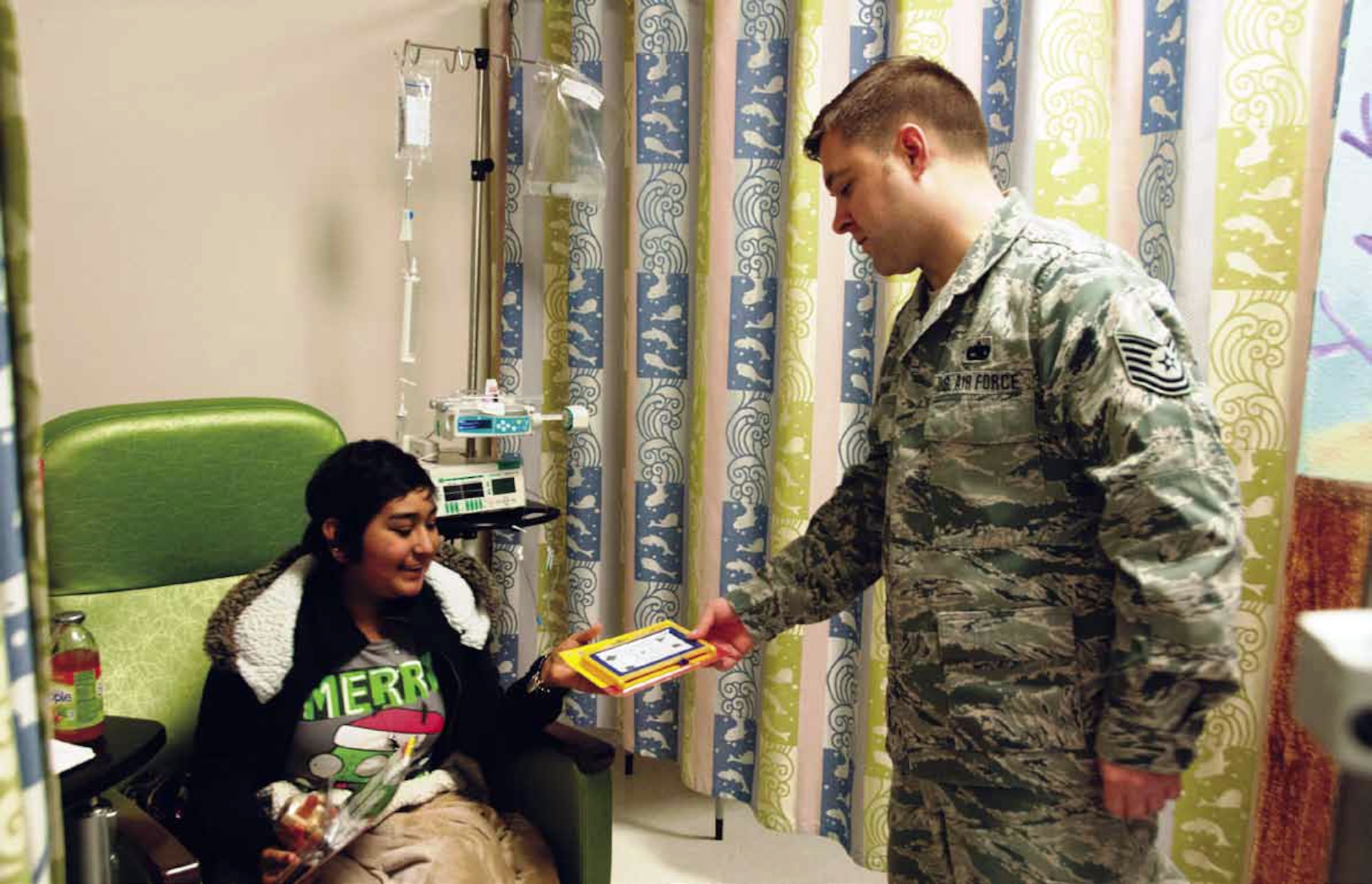 Technical Sgt. Christopher Bromm, 163d Maintenance Group, delivers toys to children who are patients at the Loma Linda University Children's Hospital, Dec. 14, 2012. The Airmen from the California Air National Guard wanted to visit and brighten the children's day with gifts as the children receive care at the out-patient center where they often have to go a few times a week. (U.S. Air Force photo by Master Sgt. Julie Avey)