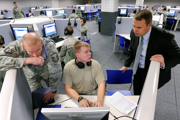 Master Sgt. Jesse Chervinka and Jessie Rhom help a cadet process an Electronic Questionnaire for Investigations Processing, or e-QIP, form in the Foreign Language Lab here Jan. 12, 2013. Information Protection Directorate officials process between 650 and 700 cadet applications for top-secret clearance annually. Chervinka is the Academy military training NCO for Cadet Squadron 31. Rhom is the IP Directorate's personnel security chief. (U.S. Air Force photo/Mike Kaplan)