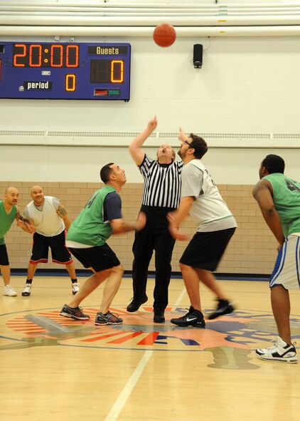 Members of the 319th Security Forces Squadron and 69th Reconnaissance Group anticipate the opening tip of the over-30 basketball championship game Jan. 9, 2013, at the Fitness Center on Grand Forks Air Force Base, N.D. The 69th RG team defeated the 319th Security Forces Squadron 46-40 to take the championship trophy. (U.S. Air Force photo/Airman 1st Class Xavier Navarro)