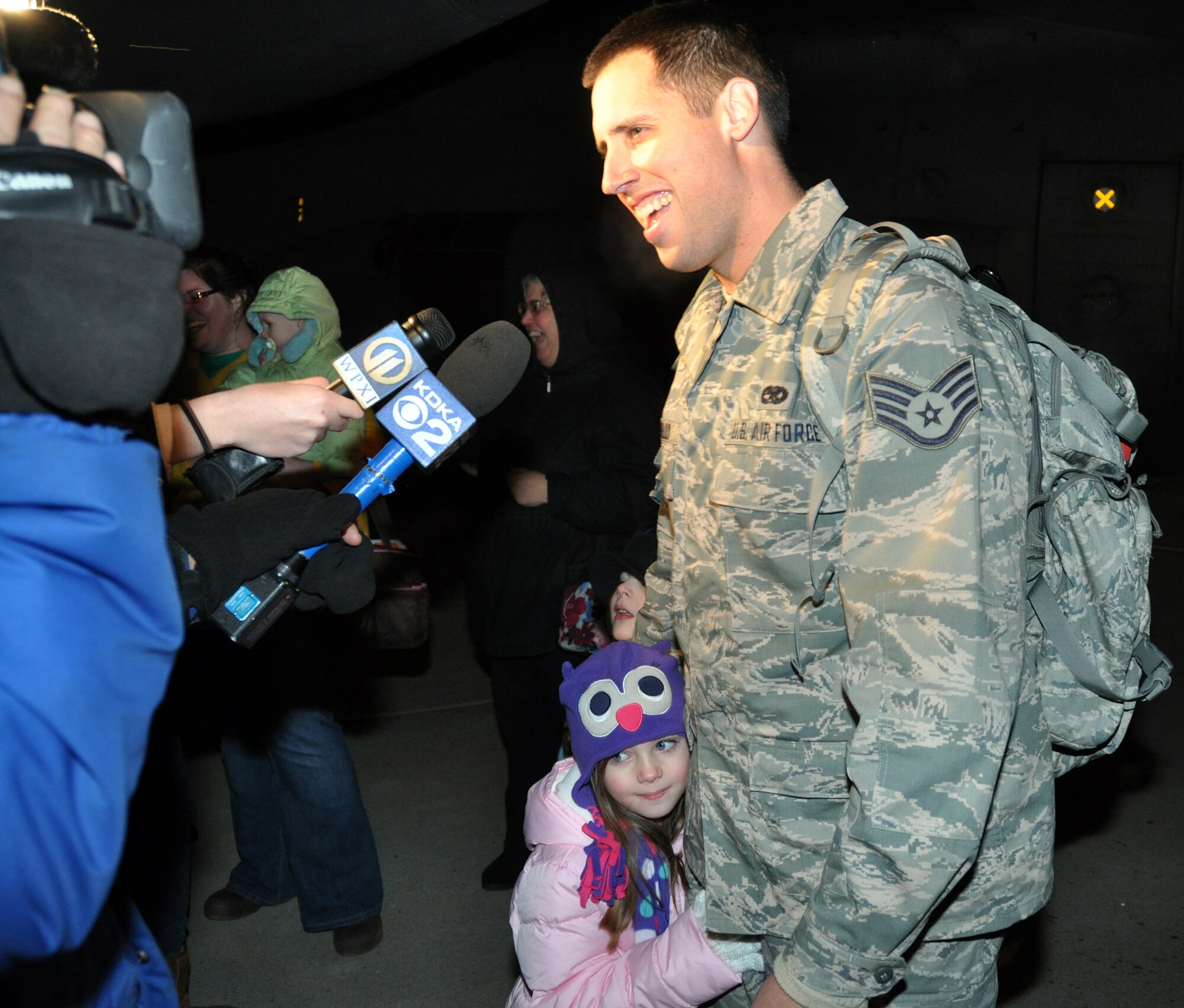 Staff Sgt. Brian E. Connelly, with daughter Kailyn at his side, speaks with local reporters immediately after reuniting with his family, Jan 17, 2013, following his return from a four-month long deployment to Southwest Asia in support of Operation Enduring Freedom.  While in Southwest Asia unit members provided critical tactical airlift to the Arabian Gulf, Africa, and Afghanistan.  Over the course of the four-month deployment the squadron flew more than 800 sorties, flying more than 2,000 combat hours and moving approximately 6,000 passengers, 3,000 short tons of cargo, 300 patients, and 129 distinguished visitors.  Equally impressive, the operations, maintenance, and support team achieved a 98 percent mission effectiveness rate and a 100 percent mission completion rate. (U.S. Air Force photo by Senior Airman Joseph E. Bridge/Released)