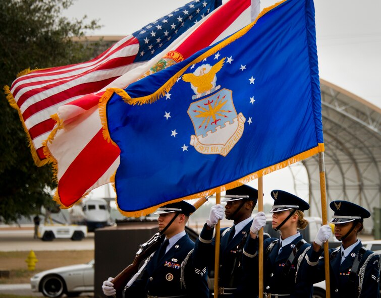 The wind whips through the flags held by the Eglin honor guard during the Senior Airman Josh Santos memorial Jan. 13 at Duke Field. Santos passed away Nov. 26 from colon cancer.  He was a radio operator with the 711th Special Operations Squadron.  During the memorial, it was announced the Duke Field gym would be renamed Santos Strength in his honor.  (U.S. Air Force photo/Tech. Sgt. Samuel King Jr.)