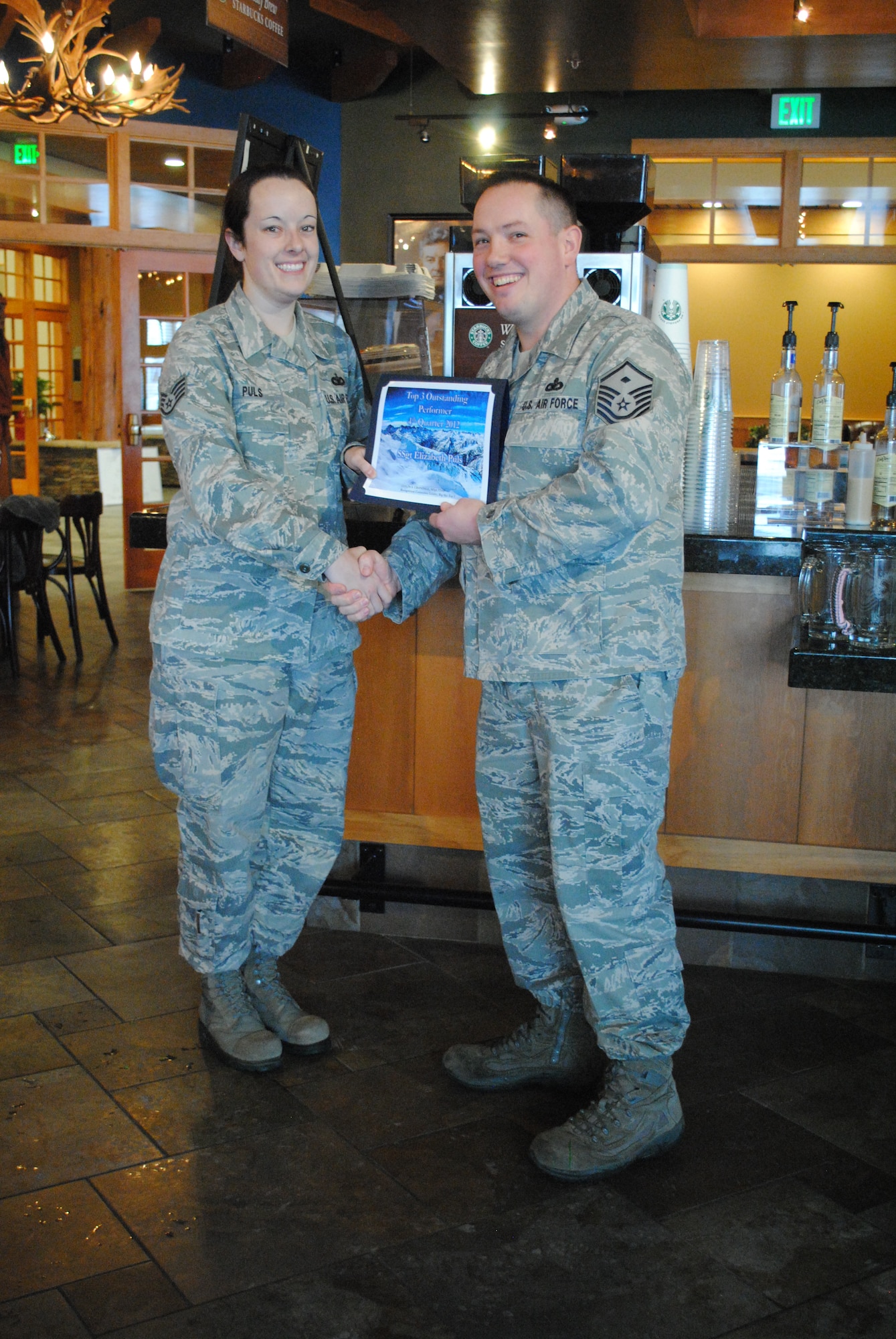 Staff Sgt. Elizabeth Puls, 341st Missile Security Forces Squadron security controller, receives a certificate for being the 4th Quarter Top 3 Outstanding Performer from Master Sgt. Collin Crandall, 341st Civil Engineer Squadron first sergeant, Jan. 15 at the Grizzly Bend. Puls was nominated for the award based on her “behind the scenes” work ethic and displayed superior leadership and followership traits. Section, shop, flight chiefs and NCO’s in-charge may submit a candidate through the sponsorship of a Top 3 member. For more information, call Crandall at 731-6187 or Master Sgt. Shannon Wells at 731-4950. (U.S. Air Force photo/Airman 1st Class Katrina Heikkinen)