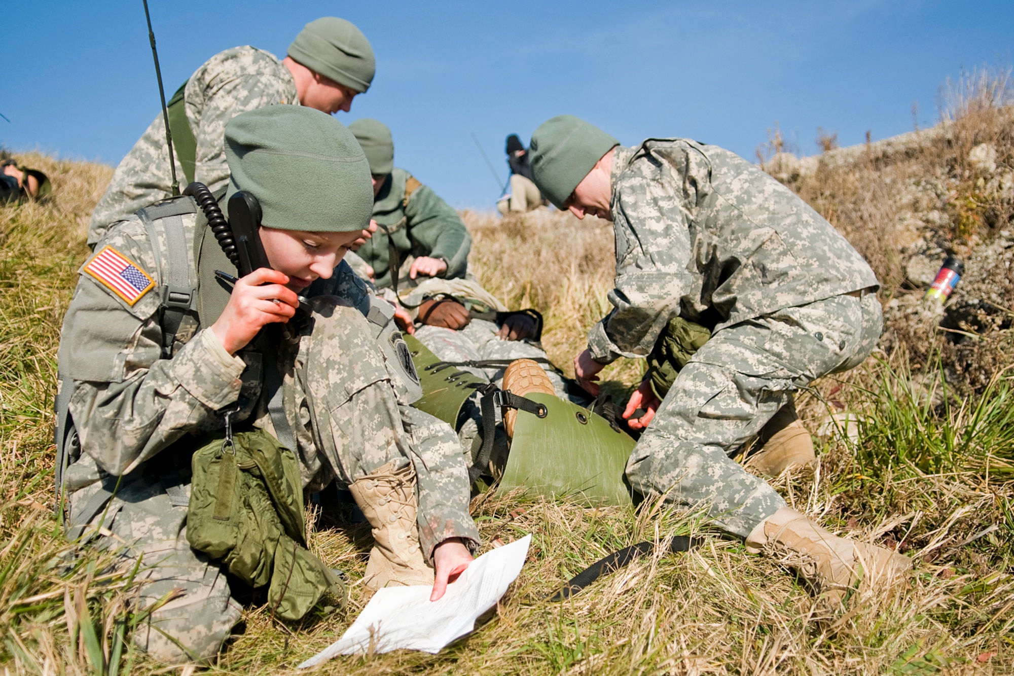 GRISSOM AIR RESERVE BASE, Ind. -- U.S. Army Reserve Spec. Rebekah White, 316th Psychological Operations Company psychological operations specialist, calls in a simulated wounded Soldier's condition using a 9-line report to David Petroski, a contract CLS instructor seen in black, while other Soldiers of her team work to prepare the injured for transport during a combat lifesavers training course here recently. The 316th PSYOP Co. went through more than a month of predeployment training, including the CLS course, prior to deploying to the Horn of Africa in support of Operation Enduring Freedom.  (U.S. Air Force photo/Tech. Sgt. Mark R. W. Orders-Woempner)
