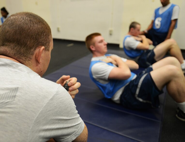 U.S. Air Force Senior Airman Christopher Wewetzer, 20th Maintenance Operations Group assistant base engine manager, evaluates an Airman during the sit-up portion of the physical training evaluation at Shaw Air Force Base, S.C., Jan. 16, 2013. Since October 2012, military members have taken over conducting physical training tests. (U.S. Air Force photo taken by Senior Airman Tabatha Zarrella/released)