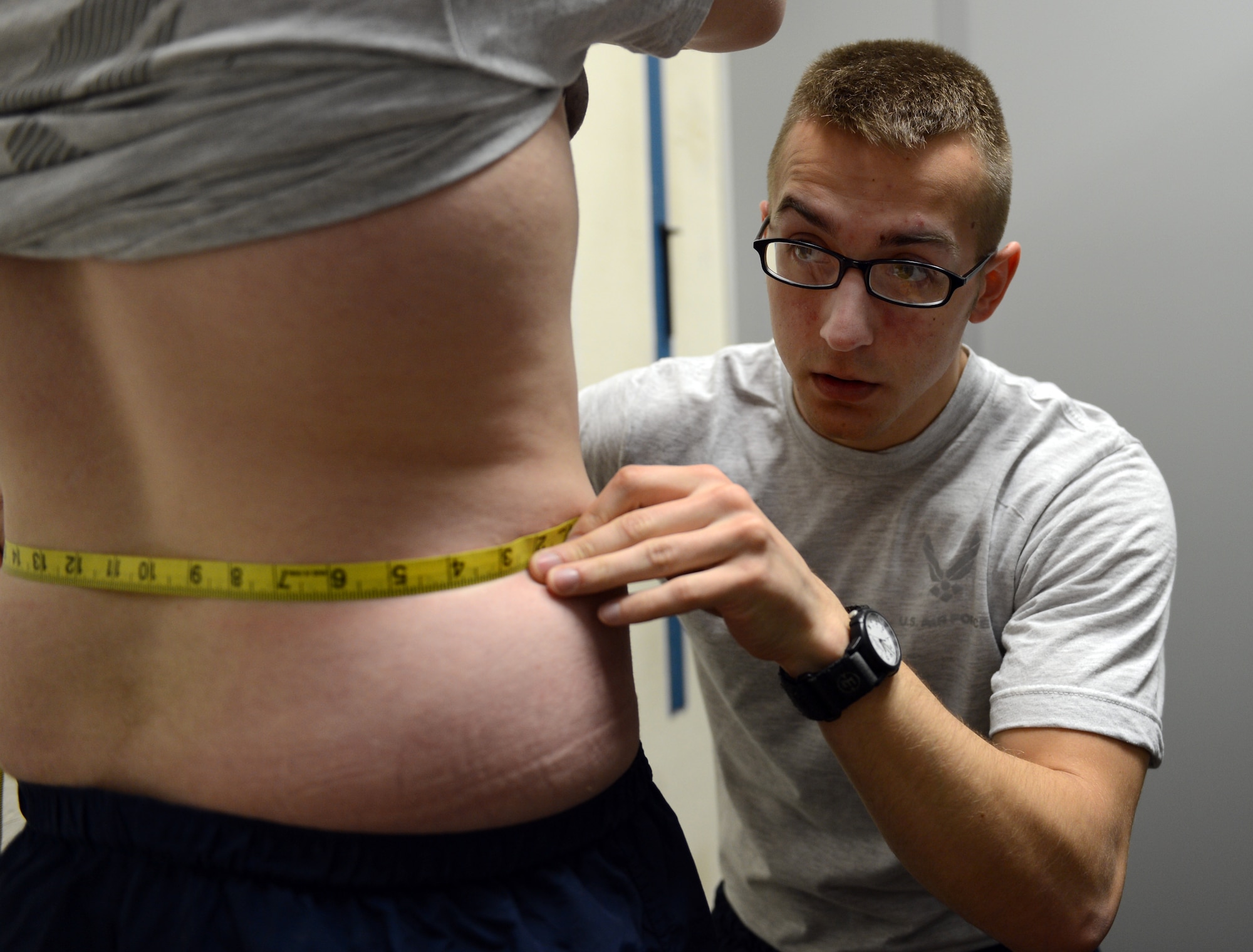 U.S. Air Force Airman 1st Class Schyler Turpin, Air Forces Central weapons of mass destruction target analyst, measures an Airman?s waist during a physical training evaluation at Shaw Air Force Base, S.C., Jan. 16, 2013. Since October 2012, military members have taken over conducting physical training tests. (U.S. Air Force photo taken by Senior Airman Tabatha Zarrella/released)
