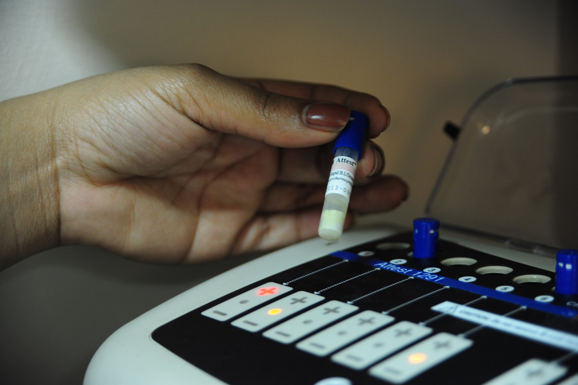 Staff Sgt. Malinda Schoolfield , 39th Medical Operations Squadron dental assistant, inspects a control vial in an Attest Auto Reader to ensure the machine is working properly Jan. 16, 2013, at Incirlik Air Base, Turkey. The control is always set to positive so the machine knows the difference between a positive and negative result when determining if germ spores have been eliminated. (U.S. Air Force photo by Senior Airman Anthony Sanchelli/Released)