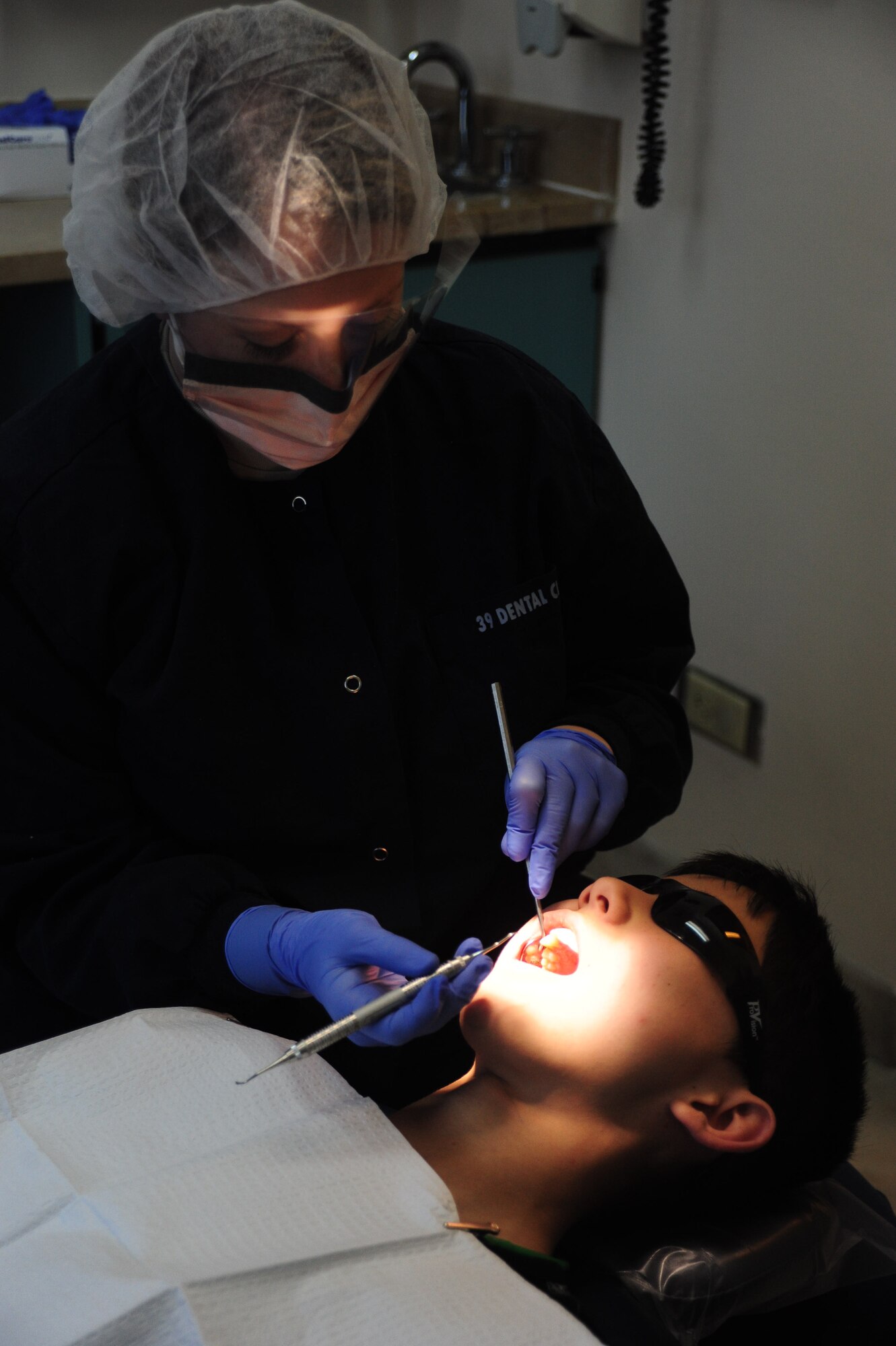 Senior Airman Megan Luscier, 39th Medical Operations Squadron dental technician, cleans a patient’s teeth during a routine check-up Jan. 16, 2013, at Incirlik Air Base, Turkey. The base dental clinic performs annual cleaning on servicemembers and family members at Incirlik. (U.S. Air Force photo by Senior Airman Anthony Sanchelli/Released)
