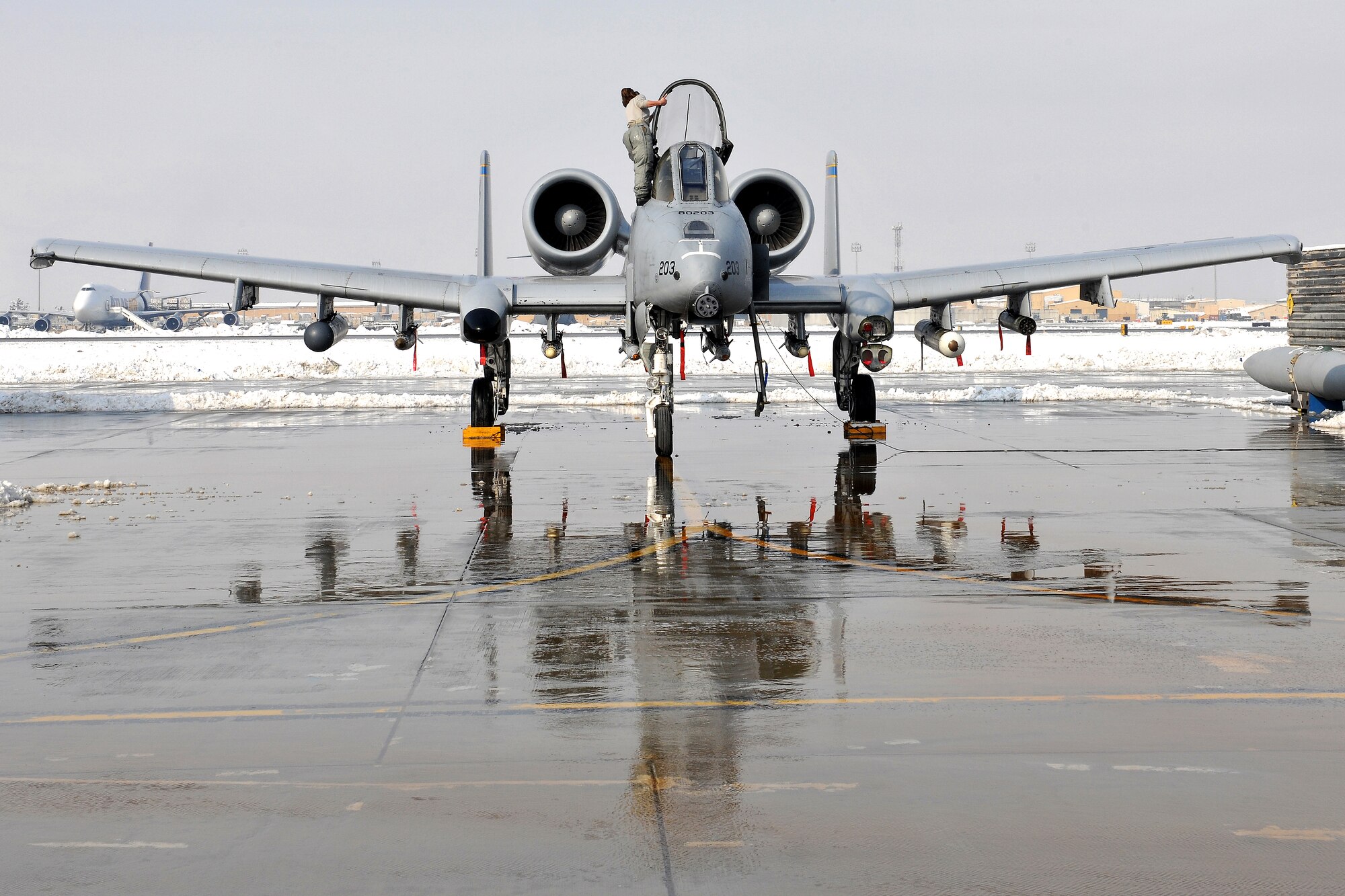 Staff Sgt. Miranda Downs, 455th Expeditionary Aircraft Maintenance Squadron, wipes snow off of an A-10 Thunderbolt II at Bagram Airfield, Afghanistan, Jan. 13, 2013. Downs is part of a team from 455th EAMXS that removed snow from the aircraft in preparation for its close air support mission. (U.S. Air Force photo/Senior Airman Chris Willis)