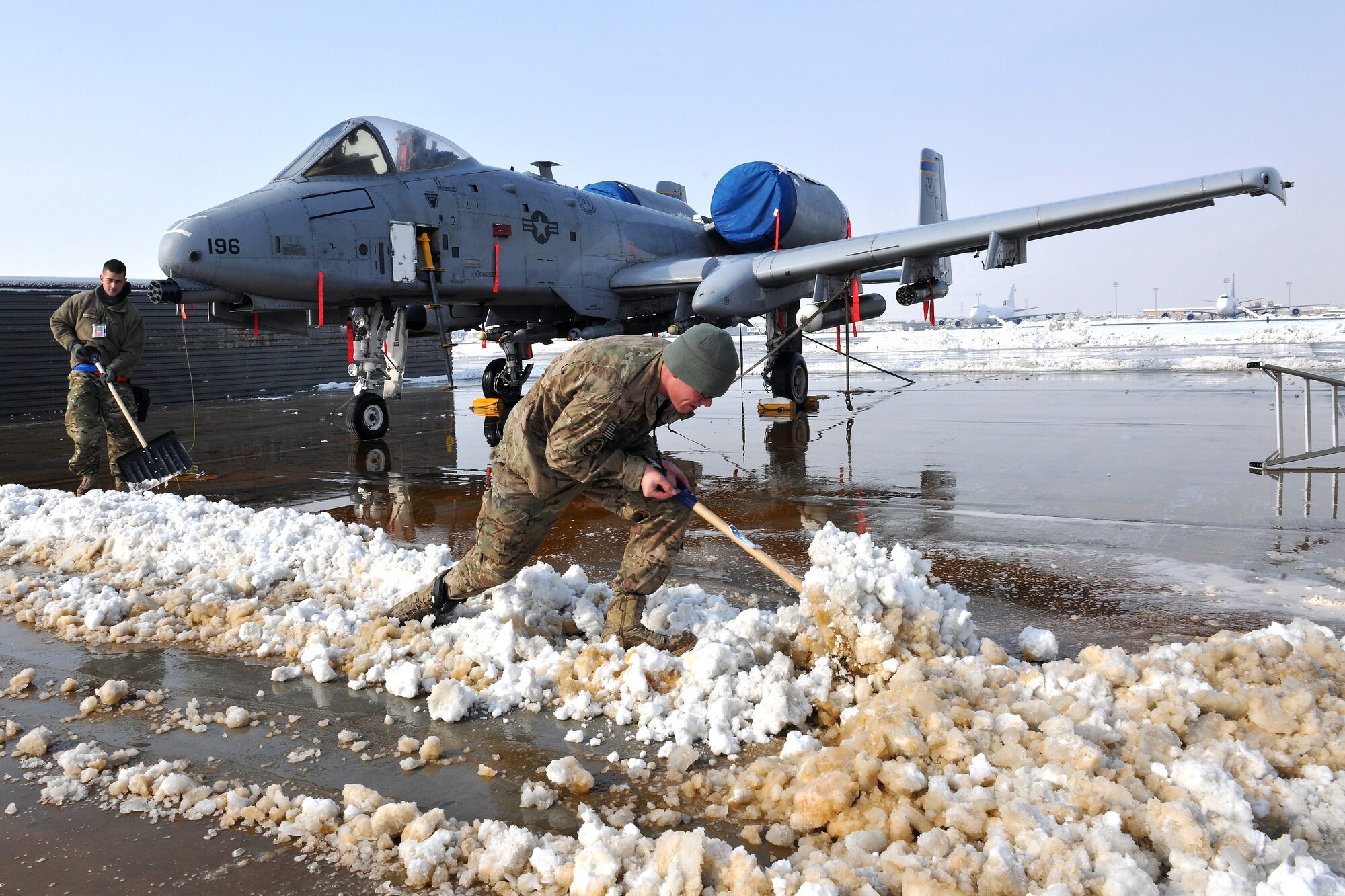 Members of the 455th Expeditionary Aircraft Maintenance Squadron clear snow around an A-10 Thunderbolt II at Bagram Airfield, Afghanistan, Jan. 13, 2013. Maintenance Airmen removed snow from the aircraft and flightline to minimize the possibility of damage prior to taxi and takeoff. (U.S. Air Force photo/Senior Airman Chris Willis)