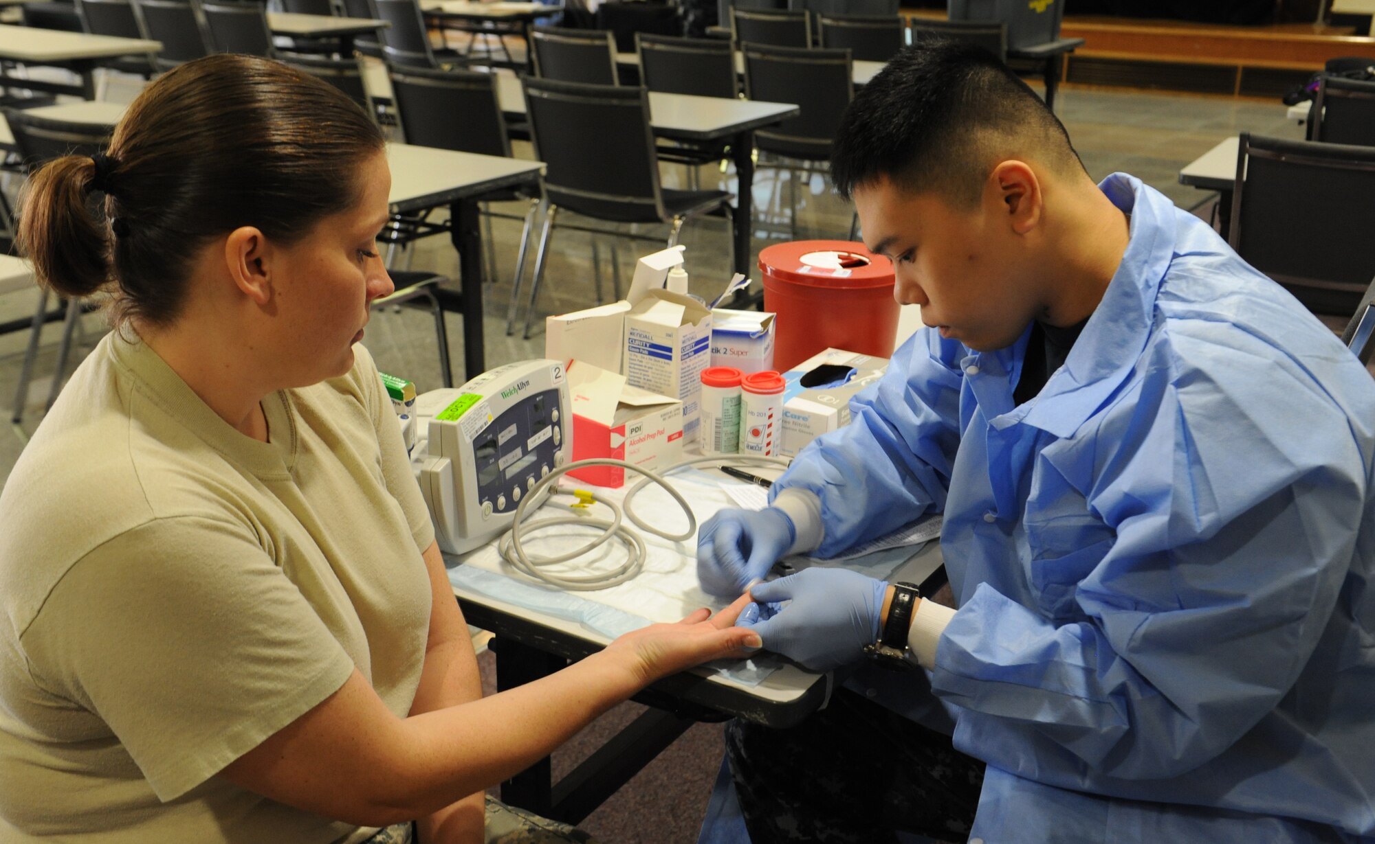 U.S. Air Force Staff Sgt. Tracy Powell, 18th Equipment Maintenance Squadron aircraft structural maintenance, has her finger cleaned by Petty Officer 3rd Class Danny Nguyen, U.S. Armed Services Blood Bank lab technician, during the Martin Luther King Blood Drive on Kadena Air Base, Japan, Jan. 17, 2013. The blood drive was held to remember Martin Luther King Jr. and inform people about his impact on American history. The drive was also one of three events dedicated to remembering MLK. (U.S. Air Force photo/Airman 1st Class Malia Jenkins)
