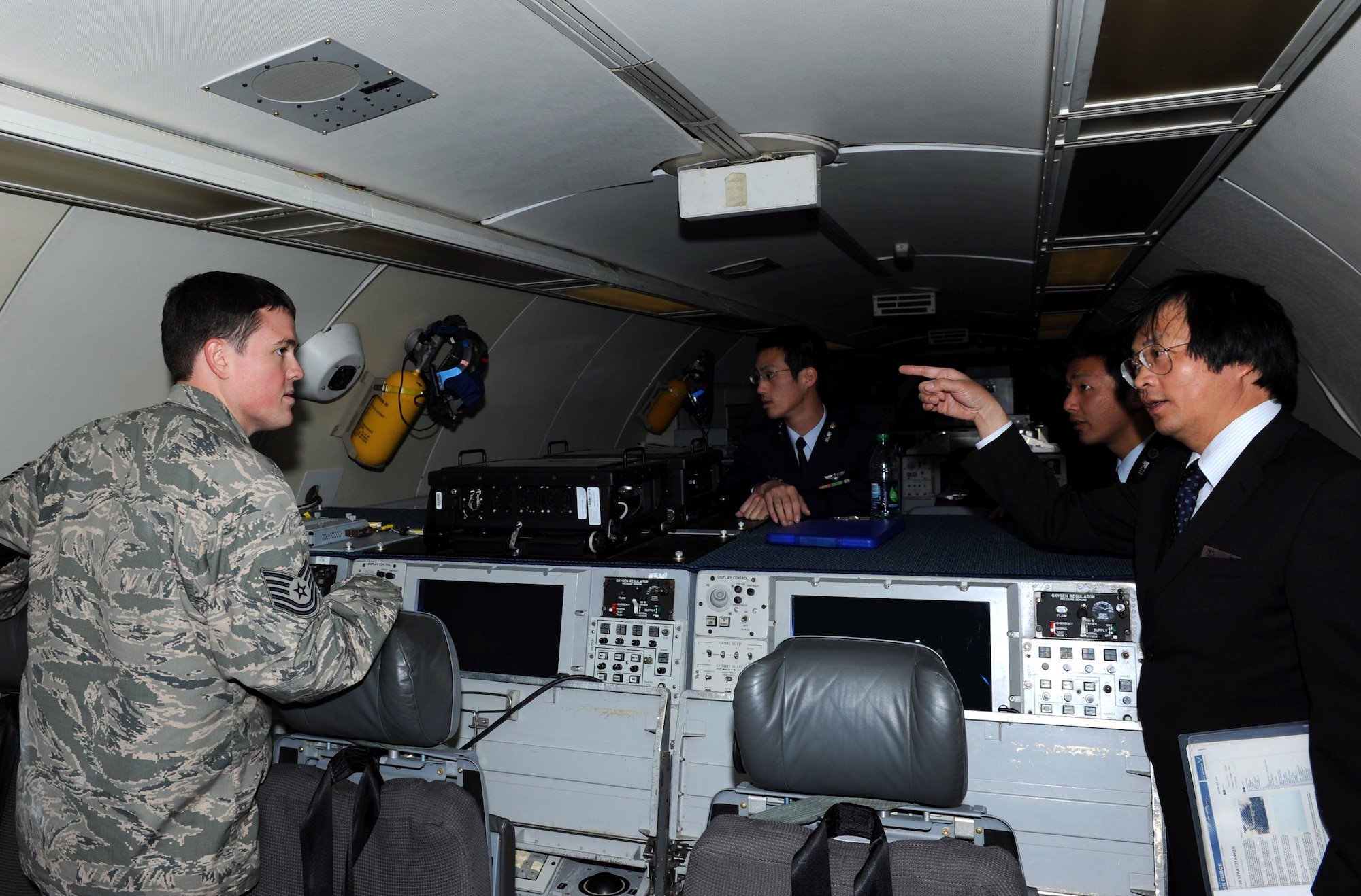 Hiroaki Mori, an interpreter and English instructor to Japan Air Self-Defense Force cadets, asks U.S. Air Force Tech. Sgt. Sean Berkshire, 961st Airborne Air Control Squadron radar lead technician, a question about a dial indication device on an E-3 Sentry at Kadena Air Base, Japan, Jan. 17, 2013. The E-3 Sentry is an airborne warning and control system aircraft that provides all-weather surveillance, command, control and communications needed by U.S and other allied air defense forces commanders. The JASDF cadets received briefings on the E-3 Sentry, as well as a briefing on the KC-135 Stratotanker prior to taking tours of the aircraft during their visit to Kadena. (U.S. Air Force photo/Airman 1st Class Hailey R. Davis)