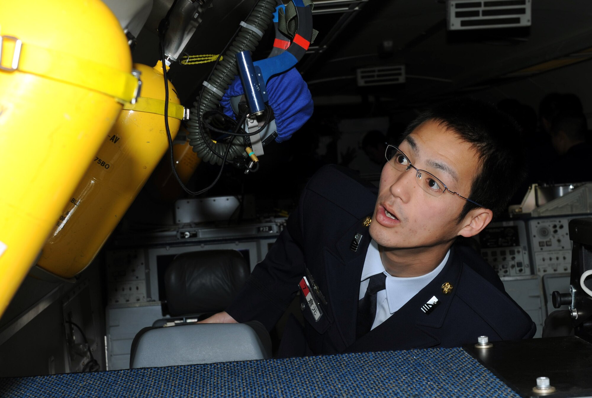 A Japan Air Self-Defense Force cadet observes oxygen tanks on an E-3 Sentry, a modified Boeing 707 on Kadena Air Base, Japan, Jan. 17, 2013. The E-3 Sentry is an airborne warning and control system aircraft that provides all-weather surveillance, command, control and communications needed by U.S. and allied air defense forces commanders. The JASDF cadets received briefings on the E-3 Sentry, as well as a briefing on the KC-135 Stratotanker prior to taking tours of the aircraft during their visit to Kadena. (U.S. Air Force photo/Airman 1st Class Hailey R. Davis)