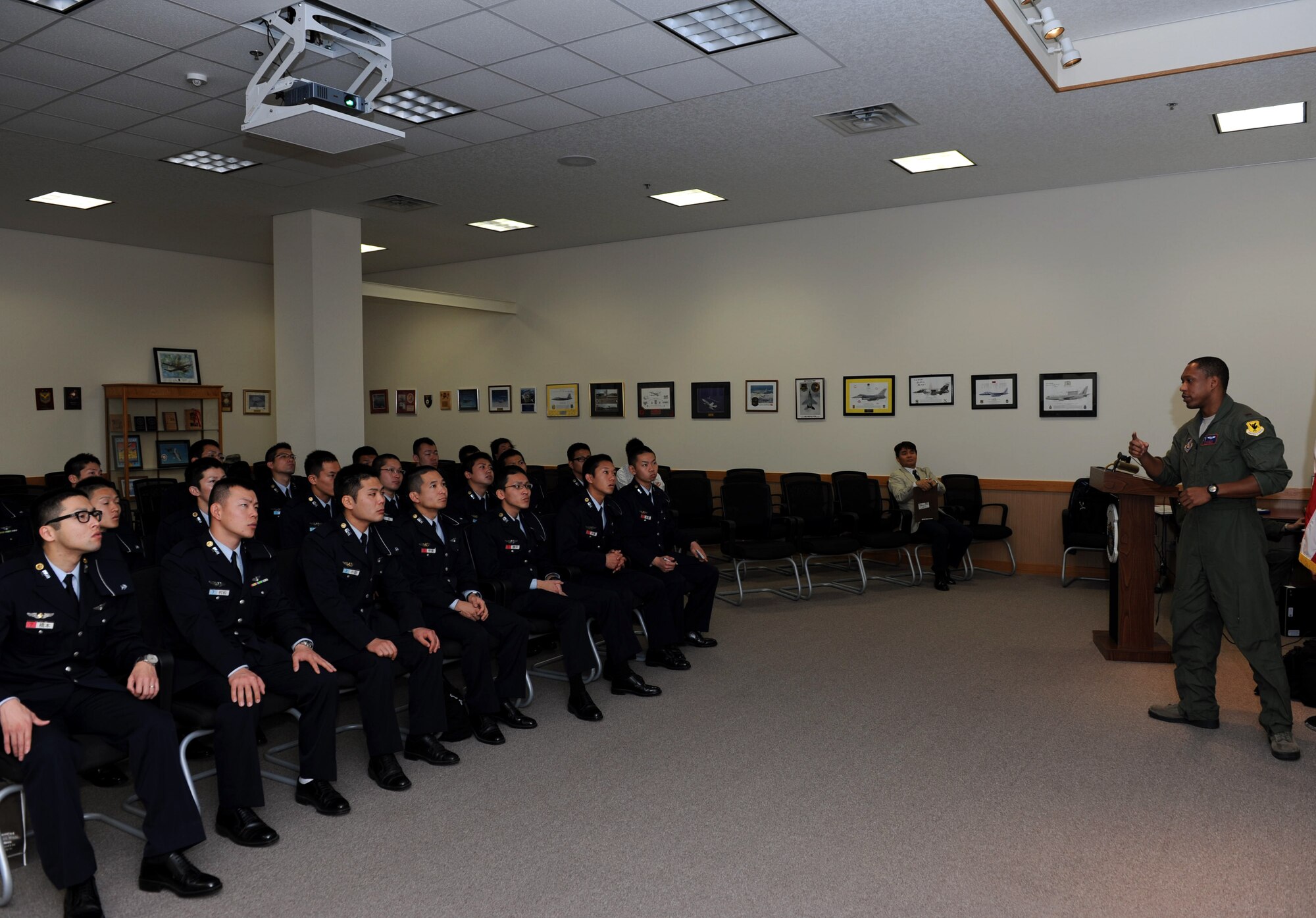 U.S. Air Force 2nd Lt. Craig Black, 961st Airborne Air Control Squadron air weapons officer, gives a briefing about the E-3 Sentry, a modified Boeing 707, to Japan Air Self-Defense Force cadets on Kadena Air Base, Japan, Jan. 17, 2013. The JASDF members received the briefing prior to joining E-3 Sentry maintainers on the flightline to tour the aircraft. (U.S. Air Force photo/Airman 1st Class Hailey R. Davis)