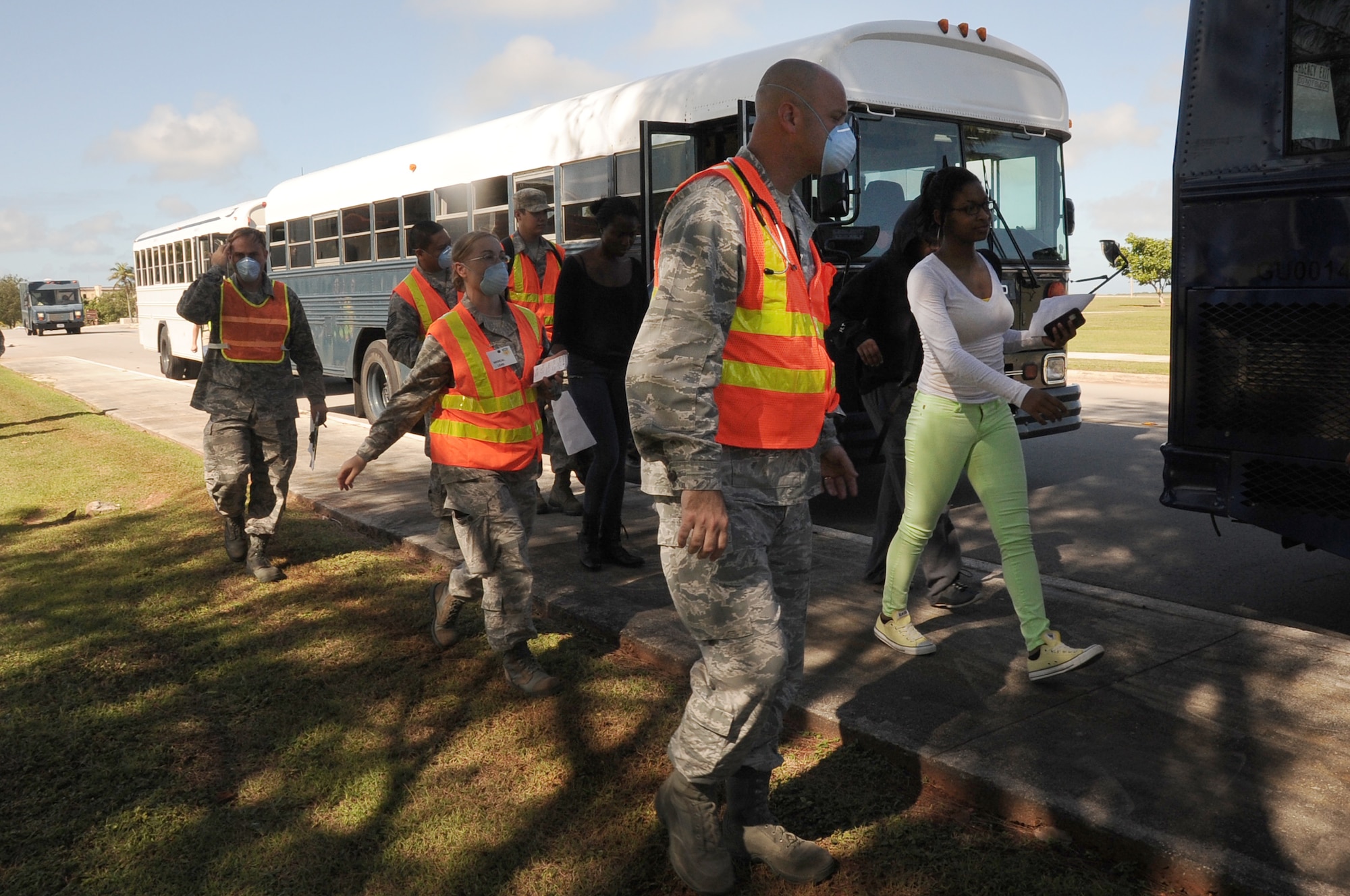 Medical personnel from the 36th Medical Group assist simulated evacuees during a noncombatant evacuation order scenario as they arrive at the Hot Spot gym on Andersen Air Force Base, Guam, Jan. 14, 2013.  Andersen is conducting the scenario as part of an operational readiness exercise to test the base’s response capabilities. (U.S. Air Force photo by Airman 1st Class Adarius Petty/Released)