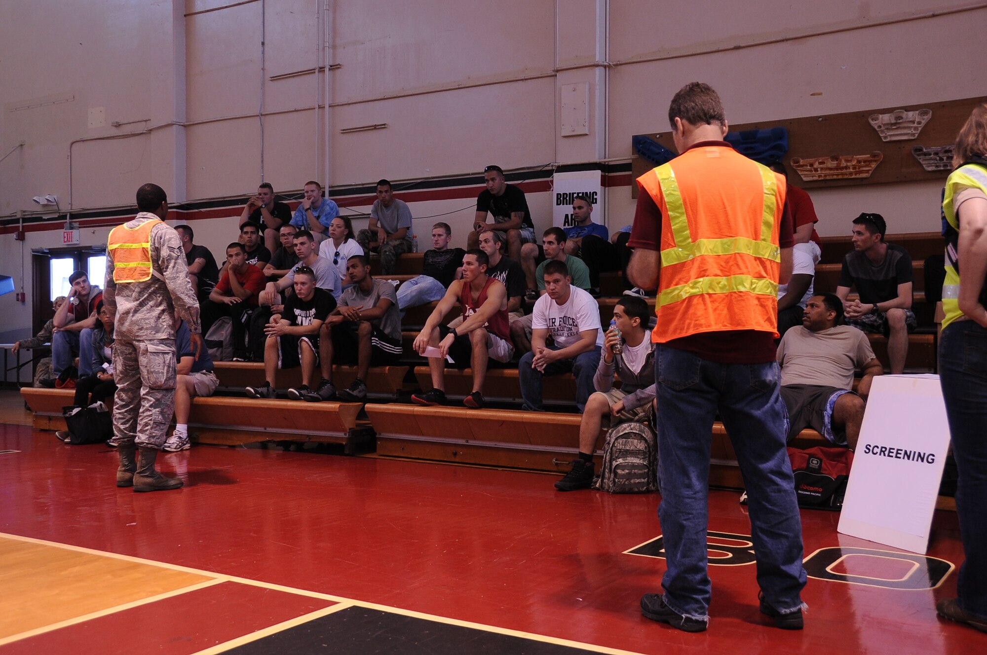 Senior Airman Robert Hicks, (left), from the 36th Wing Public Affairs office, briefs simulated evacuees of a noncombatant evacuation order scenario upon their arrival to Andersen Air Force Base, Guam, Jan. 14, 2013. Members of Andersen are conducting the scenario as part of an operational readiness exercise to ensure they are prepared to support a real-world noncombatant operation evacuation order in the Pacific region. (U.S. Air Force photo by Airman 1st Class Adarius Petty/Released)