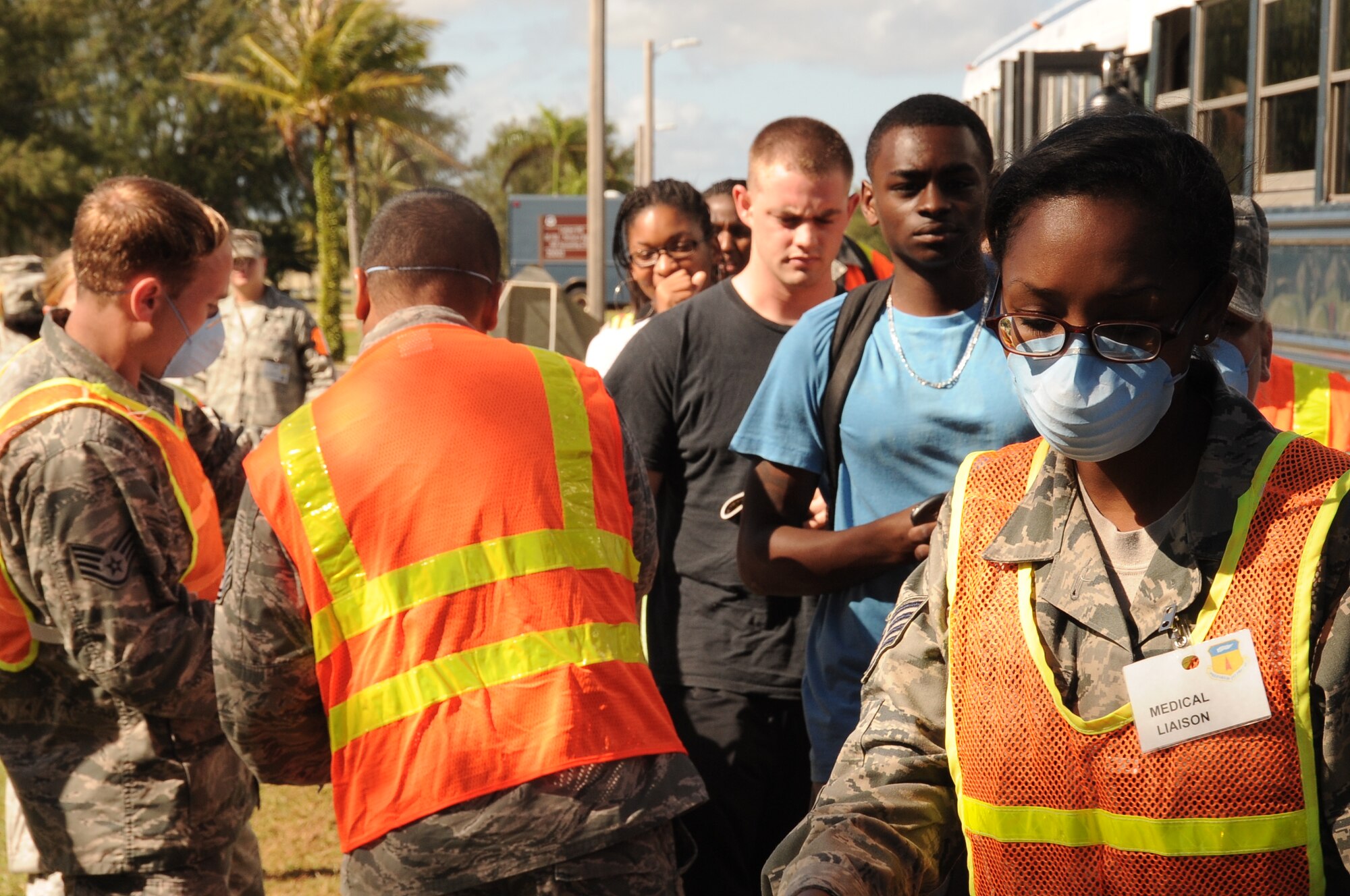 Medical liaisons from the 36th Medical Group assist simulated evacuees during a noncombatant evacuation order scenario as they arrive at the Hot Spot gym on Andersen Air Force Base, Guam, Jan. 14, 2013.  Andersen is conducting the scenario as part of an operational readiness exercise to test the base’s response capabilities. (U.S. Air Force photo by Airman 1st Class Adarius Petty/Released)